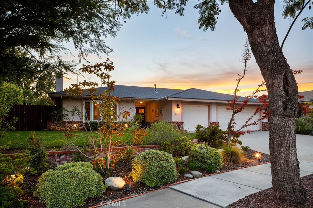 In the heart of North Claremont, this beautifully designed single-story home offers undeniable curb appeal with its expansive front yard, lush landscaping, and clean lines. A spacious three-car garage complements the home’s broad frontage and adds ample storage and parking. Inside, warm hardwood floors flow seamlessly into the open-concept layout, creating a natural sense of space and cohesion throughout the home. Just off the entryway, the living room offers generous proportions, a custom stone fireplace, and a cozy reading nook; an inviting space to relax or entertain. The adjacent dining room is equally spacious and connects to the kitchen. The kitchen is tastefully updated with custom cabinetry, sleek stainless steel appliances, a built-in gas cooktop, a dedicated wine refrigerator, and a large center island that doubles as a breakfast counter. There’s an abundance of counter space and storage, including a walk-in pantry. The kitchen opens directly to the family room, a bright and welcoming space with backyard views and direct access to the outdoors, offering a ceiling fan and built-in speakers. The home features four well-sized bedrooms and 2.5 bathrooms. The primary suite is a standout, offering backyard views, direct access to the patio, and a tranquil atmosphere. Its en-suite bathroom includes dual sinks, a dedicated vanity area, a soaking tub, a walk-in shower and a large walk-in closet. The interior brings together comfort, function, and style, creating a space that feels both refined and livable. The backyard offers a peaceful retreat with multiple areas to lounge, dine, or entertain, all surrounded by mature greenery that ensures privacy and tranquility. A seamless extension of the interior, this beautifully landscaped space is perfect for morning coffee, quiet afternoons, or sunset gatherings. Whether relaxing or hosting guests, the outdoor setting enhances the home’s charm. Adding to its uniqueness, a curated cactus garden lines the side of the house, blending natural beauty with low-maintenance appeal.