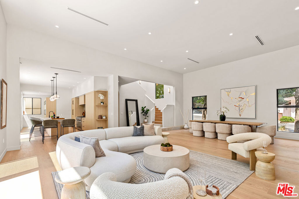 This exceptional Brentwood residence blends striking architectural design with modern luxury, set on a rare double lot. Behind a grand 10-foot wooden entry door lies a 4-bedroom, 6-bathroom layout, including two elegant powder rooms. The primary suite offers a spa-inspired retreat with dual vanities, a freestanding tub, and a custom walk-in closet. The gourmet kitchen showcases high-end appliances, while the open-concept living and dining areas feature soaring 14-foot ceilings and seamless indoor-outdoor flow to an alfresco dining space ideal for entertaining. Recent upgrades include new hardwood floors, black aluminum sliding doors, a newly added theater room and a spacious entertainment room with a fireplace complement the newly built pool and spa. Additional enhancements include a fire-resistant metal roof and all-new electrical and plumbing systems. A three-car garage provides ample parking and storage.Sophisticated yet inviting, this home embodies contemporary elegance in one of Los Angeles' most sought-after neighborhoods.