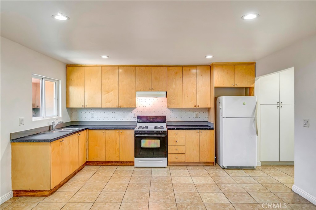Welcome to this bright and spacious 1-bedroom, 1-bathroom apartment offering approximately 900 square feet of comfortable living space. Thoughtfully designed with functionality in mind, this unit is move-in ready and filled with natural light.
The open kitchen features sleek granite countertops, ample cabinet storage in warm natural wood tones, and appliance including a gas stove. Overhead recessed lighting and a large window by the sink keep the space light and airy, making it ideal for everyday cooking and entertaining. The bedroom is generously sized with tile flooring throughout, a large window for natural light, and a built-in wall A/C unit for added comfort. You'll love the extensive built-in closet system featuring drawers, cabinets, and hanging space — perfect for staying organized. The bathroom is clean and well-appointed with a subway-tiled shower/tub combo, granite vanity counter, and modern fixtures. The warm wood cabinetry provides extra storage while keeping the space inviting.
