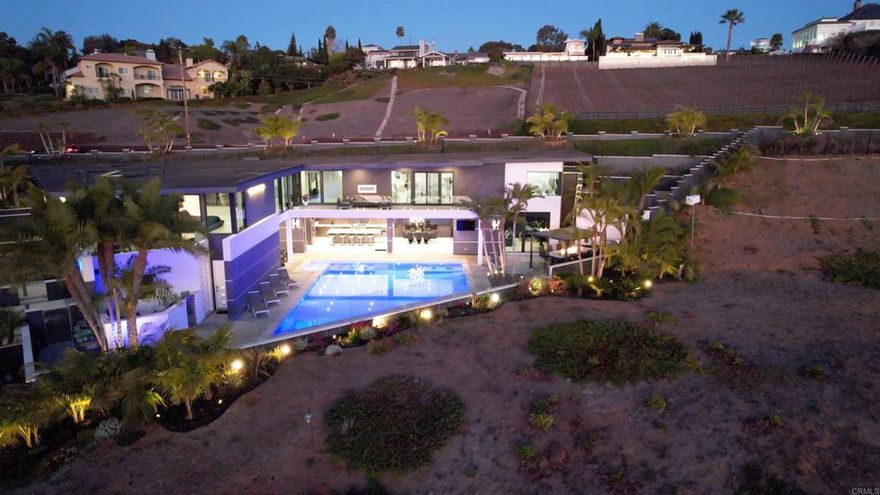 LOT #2 WITH PLANS NOW INCLUDED IN THE PURCHASE. Experience the pinnacle of luxury living with this modern, custom-built waterfront estate nestled on the tranquil lagoon in Carlsbad. Boasting unparalleled views of the lagoon and ocean, this architectural masterpiece is designed to impress at every turn. Floor-to-ceiling windows bathe the interiors in natural light, highlighting soaring ceilings and sleek contemporary lines that define the home’s sophisticated aesthetic. Step inside and be captivated by the state-of-the-art kitchen, equipped with premium stainless-steel appliances, a large center island, and seamless transitions into the spacious dining area and family room. Expansive sliding glass pocket doors open to your private backyard retreat, where a sparkling pool with in-water bar seating takes center stage. To further an entertainer's dream, this outdoor paradise also features a fully equipped BBQ, a firepit, a poolside shower, private outdoor bathroom, and a professional chef's garden all set against breathtaking lagoon and ocean vistas. The second level unveils a versatile grand loft and a luxurious primary suite that redefines indulgence. Complete with two oversized walk-in closets and a spa-like en-suite bathroom, the primary suite offers both comfort and style. Four additional bedrooms provide ample space for family or guests, while expansive decks on this level offer some of the most unparalleled panoramic views imaginable. Adding to the allure is an attached guest house, thoughtfully designed with its own kitchen, living room, bedroom, and bathroom – the perfect haven for extended family or visitors. The property’s multiple garages ensure plenty of storage and parking for all your needs. As an added bonus, the opportunity to purchase two additional lots opens endless possibilities – build a second home, a pickleball or sport court, an ADU, or even a luxury garage. This is more than a home; it’s a statement. Don’t miss the chance to own this extraordinary property that blends modern elegance with waterfront serenity.