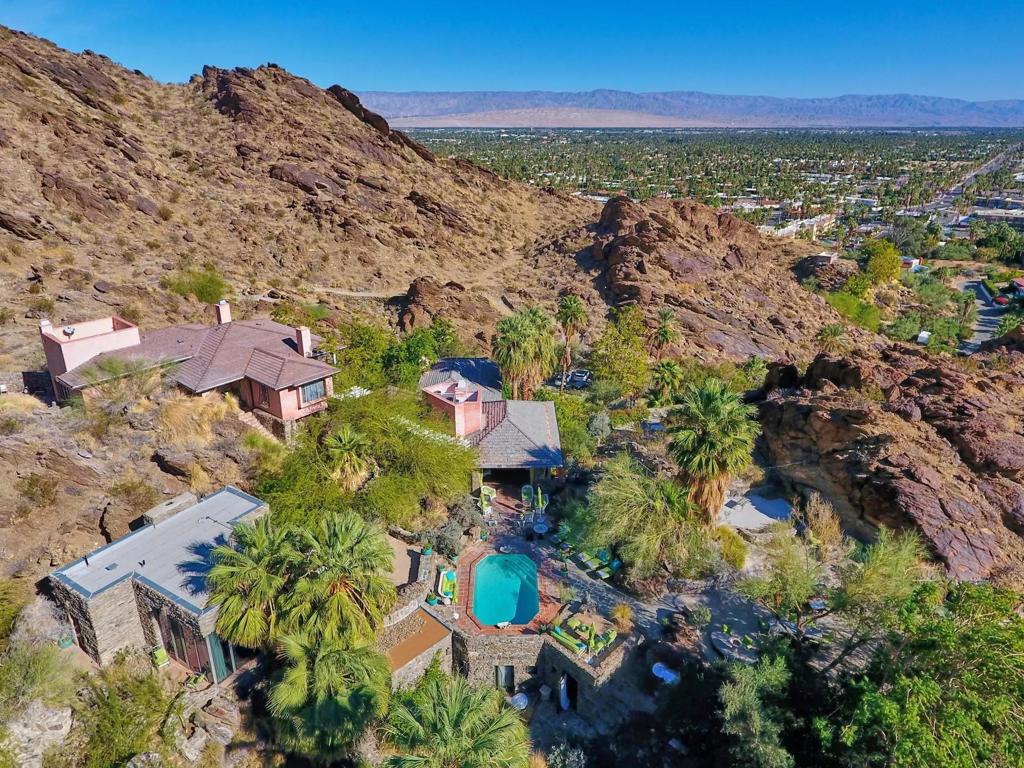 One of the most iconic estates in the entire Palm Springs Valley, ''Bellosguardo',' was begun in1924. The estate has not changed hands in close to 45 years! Nestled on more than 28 acres of magical land, this one-of-a-kind World Class estate sits at the base of Mt. San Jacinto in a hidden canyon, yet minutes to downtown Palm Springs. The 7 bedroom, 10 baths multi-structure compound features the main house plus 4 additional individual villas. Main house contains an open living room, chefs kitchen and butler's pantry as well as a secret 2000+bottle wine cellar. The formal dining room with fireplace and wet-bar can seat 32 comfortably. The master suite features a private patio, outdoor shower, dramatic dressing area, his/hers closets, 2 home offices and safe room. The guest suites offer natural rock walls and authentic architectural elements. Famed modernist architect Albert Frey designed ''The Rock House'' villa of the estate, which features a 2-room suite with walls of glass, fireplace, hand-carved Balinese garden doors, claw-foot tub, rock shower and meditation garden. Furnishings included with exceptions. . The grounds are the show with acres of entertainment areas set among spectacular rock formations and featuring a natural amphitheater with stage, swimming ponds, waterfall and hiking trails on the property itself. And at night the setting will leave you breathless. There is simply no home like this anywhere.
