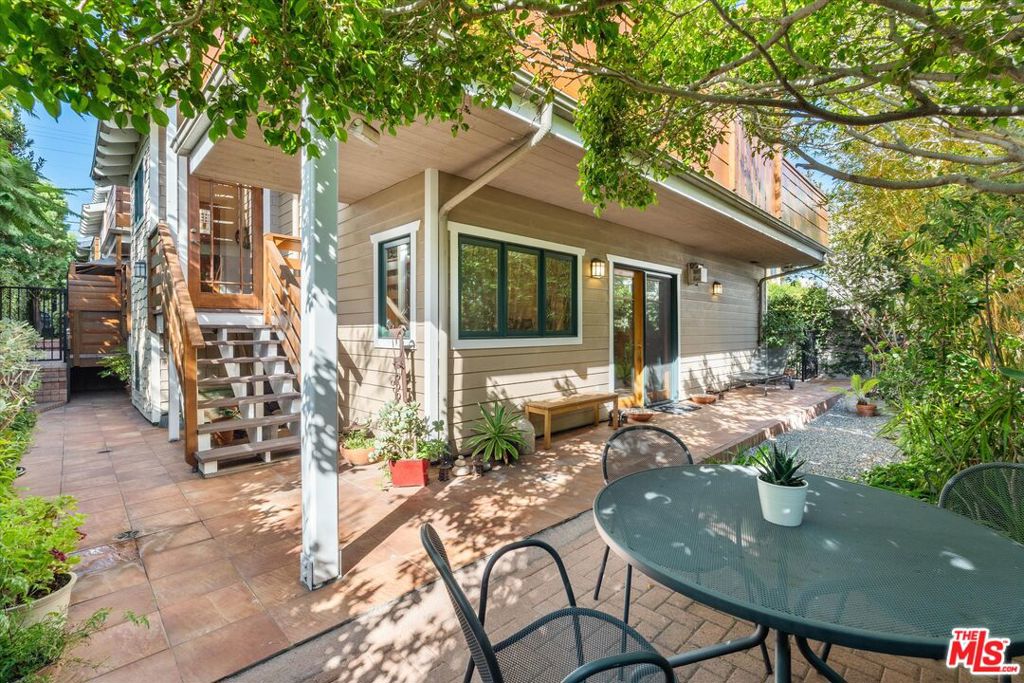 Rare Architectural Craftsman Retreat in prime Ocean Park, Santa Monica, this expansive three-bedroom, two-and-a-half-bath residence with a loft that functions as a fourth bedroom or office, plus a bonus basement room, offers over 2,500 square feet of living space and lives like a single-family home. Nestled at the back of a meticulously maintained three-unit building, this end unit provides unmatched privacy, tranquility, and a truly unique coastal lifestyle. The split-level entry leads to the bedroom level, where the spacious primary suite features a fireplace, walk-in closet, French doors that open to the expansive private backyard, and an en suite bath with dual sinks, spa tub, and separate shower. Two additional bedrooms and updated baths complete this level, including a secondary bedroom with its own private sitting area and direct access to the yard. The backyard is one of the largest you will find in any Santa Monica townhome, a rare wraparound garden sanctuary filled with greenery that provides multiple indoor-outdoor living opportunities and makes the home feel like a private residence. Upstairs, soaring beamed and vaulted ceilings, skylights, and oversized windows flood the open living, dining, and gourmet kitchen with natural light, while expansive views of the hills, treetops, and city lights create a spectacular backdrop. The chef's kitchen includes Bosch and KitchenAid appliances, a center island, and flows seamlessly into the main living area with hardwood floors, fireplace, and a large deck overlooking the gardens. A bright loft crowns the top level, offering flexibility as an additional bedroom, den, or office, with equally stunning views above. On the garage level, a versatile basement bonus room adds valuable square footage and leads directly into the home's private two-car garage, unique to this unit (only unit in complex with private 2 car garage attached). Throughout the property, incredible natural light, ocean breezes, and a serene sense of quiet enhance the feeling of retreat. Just four blocks from Santa Monica Beach, the boardwalk, bike paths, and surfing, with Main Street shops, restaurants, and cafes nearby, plus convenient access to Rose Avenue, Abbot Kinney, and all of Santa Monica, this is a must-see and rare opportunityone of the most unique homes you will find in this price range. See pvt remarks for showing requests.