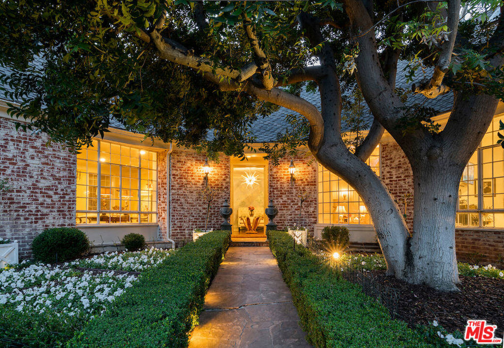 Stunning traditional residence privately tucked behind gates in the heart of Little Holmby. A dramatic stone pathway meticulously lined by greenery welcomes guests into the curved formal entry intricately adorned by hand painted walls. The formal living room, just off of the entry, showcases 10 Ft ceilings, a marble fireplace, and picture windows allowing in an abundance of natural light. On the other side of the formal entry is the formal dining room, with access to the yard, that seamlessly flows into the chef's kitchen. Black and white checkerboard marble floors perfectly compliment the stainless steel appliances, countertops, and island in addition to the cabinetry. A wood paneled den with a wet bar and fireplace provides an inviting yet polished space to entertain. The broad gallery hallway, lined by a wall of French doors, leads to the primary suite quietly tucked away in the far wing of the house. A considerable walk-in closet, spa like ensuite and a private balcony overlooking the backyard create the primary bedroom retreat. Two additional bedrooms on this level plus two bedrooms upstairs, each with its own bathroom, complete this highly functional floor plan. An expansive garden patio framed by lush greenery offers an outdoor grill and copious seating areas. An in-ground pool and spa are the finishing touches to this serene oasis in one of the most highly coveted neighborhoods in Los Angeles.