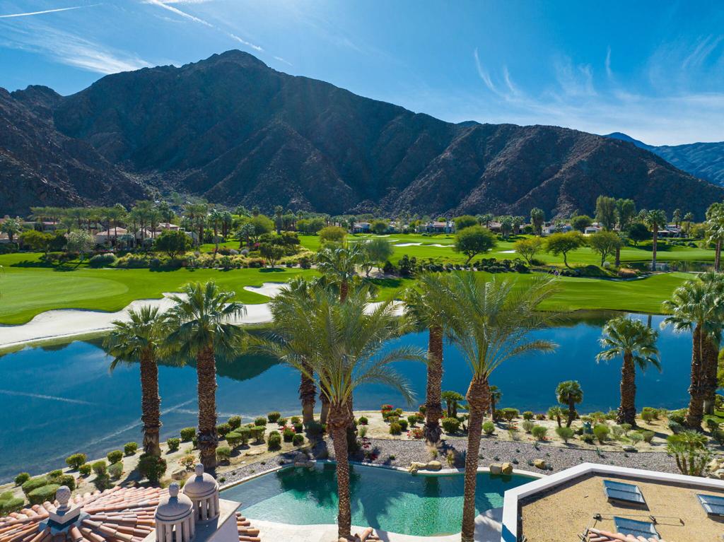 Best location and views at Tradition Golf Club! Privacy, serenity, and the ultimate entertaining house. South facing sun, with a huge wraparound pool nestled above a gorgeous lake and the 1st fairway and the 18th hole beyond. This exquisite masterpiece displays the absolute finest in craftsmanship with wood sliding pocket doors & windows, and massive beam and wood ceilings. Designed by award winning architect Gordon Stein and built with the finest materials including pillowed Beaumaniere Limestone Floors, gorgeous countertops, and handsome cabinets. Spacious gourmet cook's kitchen with gas cooktop, top of the line appliances and huge island. An entertainers dream with pocketing doors opening to south rear patio and huge outdoor covered loggia with nearby BBQ and infinity edge pool. Beautiful primary bedroom with amazing views and stunning bathroom suite. Two guest bedrooms and the 4th bedroom is setup as a handsome Office. A plethora of great amenities such as one touch lighting system, motorized blinds, and gorgeous Albertini wood windows and doors. Even a pool bathroom and extra den in the garage, which could be a 5th bedroom, gym or studio! Walk to dinner at the beautiful clubhouse just steps away from the clubhouse. The best of the best! Offered furnished per inventory. Seller prefers April 15 close of escrow.