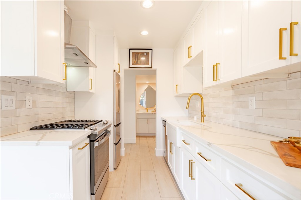 This beautifully upgraded, ground-level, single-story end-unit 1 bed, 1 bath home is truly TURNKEY. Step inside to discover a FULLY REMODELED KITCHEN & BATHROOM, featuring new ceramic tile plank flooring throughout. The kitchen is a dream for any entertainer, boasting elegant quartz countertops, ceiling-height cabinetry, and stylish gold fixtures and hardware. You'll love the generous counter and storage space. The remodeled bathroom is equally impressive, offering dual vanities, upgraded quartz counters, custom cabinetry, and more of those sleek gold accents. The spacious living room is filled with natural light thanks to a large picture window, and the open floor plan flows seamlessly with a modern pass-through kitchen design. The bedroom is bright and private, complete with a walk-in closet. Step outside to your private, spacious back patio, enclosed with updated vinyl fencing for added privacy. Storage is plentiful with a covered carport that includes storage, a dedicated patio storage cabinet, and an additional storage shed. Home re-piped in 2024! Enjoy resort-style living in a well-maintained community with a sparkling pool. Centrally located near shopping, dining, entertainment, freeways, and the beautiful new local park, including track, playground & dog park. This home is a true find!