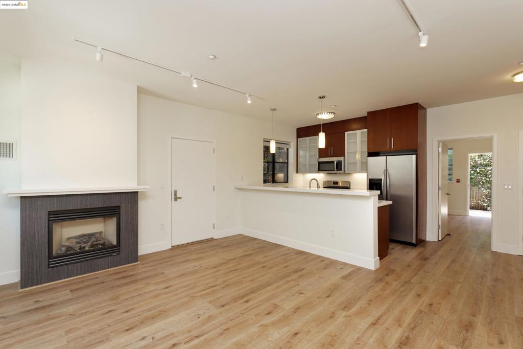 Chic 2-level Condo in Oakland’s West Clawson Neighborhood at the Emeryville border. Walkscore 86. Bikescore 95! This stylish residence was built in 2006 & is like new. Expansive industrial-style windows. Fireplace (non wood burning) in living room. Lovely exclusive-use patio at rear. Wood grained style laminate floors on both levels. 3 bedrooms (1 on lower level, 2 on upper level). Each bedroom has an ensuite bathroom. Primary upper level bedroom has abundant closet space, including a walk-in closet. Gorgeous kitchen w/cherry & glass cabinetry, designer lighting, & breakfast bar. Stainless steel kitchen appliances; gas stove. Bathrooms feature Kohler fixtures. Energy efficient hydronic heating system. Track lighting throughout. Full-sized, in-unit side-by-side washer & dryer. Common area roof deck. One (1) gated off-street parking space located directly in front of the unit. Located in the Dogtown Art District at the Oakland-Emeryville border. Downtown Oakland, Emeryville's Bay Street, and Berkeley shopping & dining nearby. Commute to SF via BART + convenient HWY access.