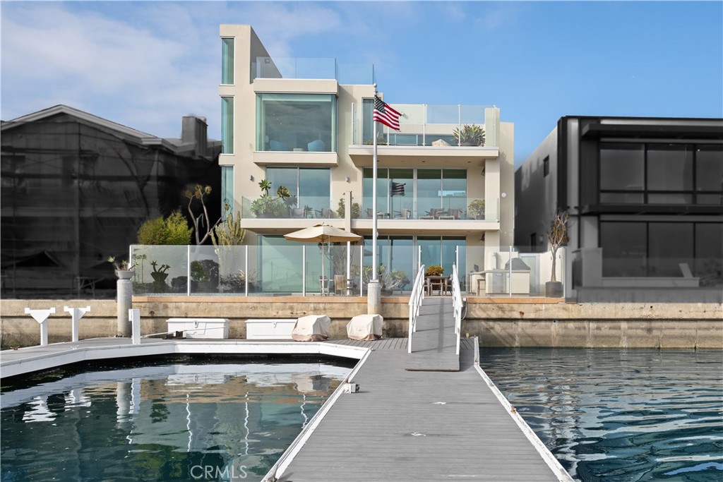 Welcome to the Naples Island Waterfront of Luxury homes on the private stretch, overlooking Alamitos Bay.
This spectacular Estate Home is a "One of a Kind" modern Masterpiece. Extensively renovated in 2004, this home is the tallest home on this exclusive location on the waterfront. Enjoy the fantastic panoramic views from all four levels, including Pristine Alamitos Bay, Catalina Island, Palos Verdes and The Peninsula. Appreciate the finest of Quality, Craftsmanship, and Materials, all used to perfection, while enjoying the expansive water views. This 4 Bedroom, 4.5 Bathrooms, 5974 sq. foot, Custom Built Modern Style is truly a work of art.
--- First floor includes a full Wet Bar, a Custom walk-in, climate controlled Wine Room with a capacity of approximately1,000 bottles, Family Room opening up to the outdoor Waterfront Veranda, including an in ground Spa Pool, custom built Barbecue Island with a Hestan Grill, Refrigerator and Storage, plus a built-in Hestan Beer dispenser, a built-in Hestan drop-in Cooler, along with a built-in Scotsman nugget Ice machine and spacious Sitting area, all set up for entertaining. This private entertainment area overlooks the 70 plus Ft Slip for multiple Watercrafts or luxury Yachts. There is also a Bedroom/Gym and Bathroom Room on this level.
--- Second level consists of a view Living Room and view Dining Room and Balcony overlooking the water, a Gourmet Chefs Kitchen and cabinetry by German manufacturer, Bulthaup, along with all Top of the Line appliances. There are Two more Bedrooms with built in Cabinetry, both with full on suite Bathrooms. The next split level has a full Office, with water views.
--- Third level is the Primary Suite and private View Deck with outdoor Fireplace. The Primary Bath is complete with a separate, stand alone Soaking Tub and oversized Walk-in Shower, dual Sinks and large Walk-in Custom Closet. There is also a second Laundry room and Office on this level.
--- Fourth level is a 360 Degrees Panoramic Rooftop View Deck, very spacious and spans the entire rooftop.
--- Ground level with street access to a Three Car Garage with Car Lift for a Fourth vehicle.
--- Special features include: Elevator to all Four levels, Air Conditioning, Custom Lighting throughout and Alarm and Security Cameras. There is a Savant AV system installed which controls the TVs, Audio, entry, climate and the Spa.
Enjoy the Indoor/Outdoor lifestyle of Naples Island living at its finest.