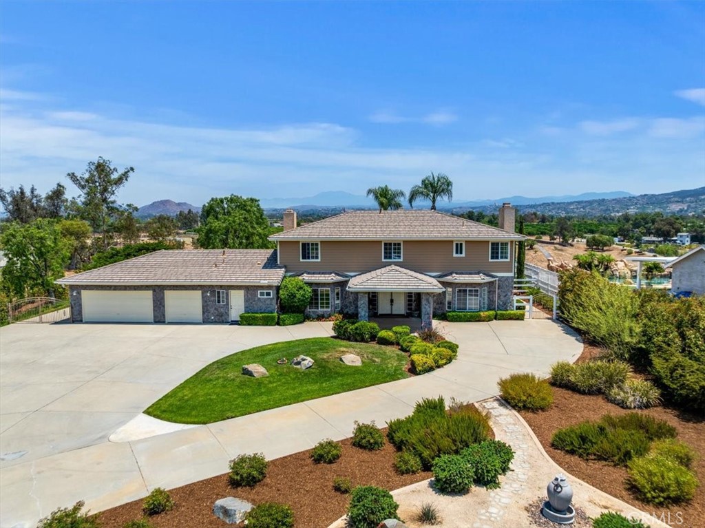 Welcome to this immaculate custom estate perfectly situated on 2.5 acres with breathtaking panoramic views of the Temecula Valley and its iconic hot air balloons. Located just minutes from town and the area’s award-winning wineries, this stunning home offers the ideal blend of privacy, space, and convenience. Featuring approximately 3,858 sq ft of beautifully upgraded living space, this residence includes 5 bedrooms, 4.5 bathrooms, and a dedicated office with built-ins that could serve as a 6th bedroom. From the moment you arrive, the stately presence is undeniable—stone-accented exterior, private wrought iron electronic entry gate, porte cochere, mature trees, and a double door entry that leads into a warm, elegant interior.
Inside, you'll find a spacious, open layout with engineered wood flooring, new downstairs carpet, crown moulding, coffered ceilings, picture windows, and French doors that frame incredible views. The home features three fireplaces—located in the living room, family room, and the primary suite—adding warmth and sophistication throughout. The gourmet kitchen includes granite countertops, custom cabinetry, double ovens, and a charming morning room filled with natural light and scenic beauty. The primary suite includes a fireplace, walk-in closet, and a beautifully upgraded bathroom featuring elegant finishes, plus a new soaking tub. French doors lead out to a private balcony with wrought iron railings and a staircase offering direct access to the backyard—ideal for enjoying peaceful mornings or quiet evenings. Secondary bedrooms are generously sized, including a Jack-and-Jill configuration upstairs for added functionality. Step outside to a backyard designed for comfort, entertaining, and enjoying the wine country lifestyle. The custom saltwater pool and spa are surrounded by lush landscaping, mature trees (including numerous fruit trees), and open space to unwind or gather with friends. The expansive 2.5-acre lot provides ample room for horses, a sport court, or a future guest house—plus, there's convenient secondary access to the lower part of the property from the road behind. Additional highlights include RV parking with 220V hookup, an oversized three-car garage with built-in cabinets, a custom 8–10 person sauna, and included refrigerator, washer, and dryer. With no HOA and low taxes, this exceptional property is a rare opportunity to enjoy the very best of Temecula’s lifestyle, space, and views.