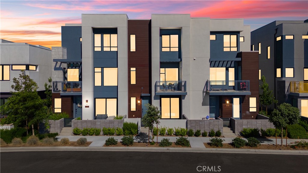 Newly built, light-filled luxury townhome at The Landing in Tustin Legacy, showcasing over $100K in curated upgrades. Features 12’ ceilings, imported Italian stone floors, a stainless steel JennAir/KitchenAid appliance suite, full-height maple cabinetry, and matte black designer finishes. Google Home smart system, solar panels, EV charger, instant hot water, and SpringWell whole-home water filtration elevate daily living. Includes a versatile ground-level flex space with full bath. Premier lot with rare views of JWA, Disneyland fireworks, and the iconic FLIGHT building. Walk to The District, parks, dining, and more.