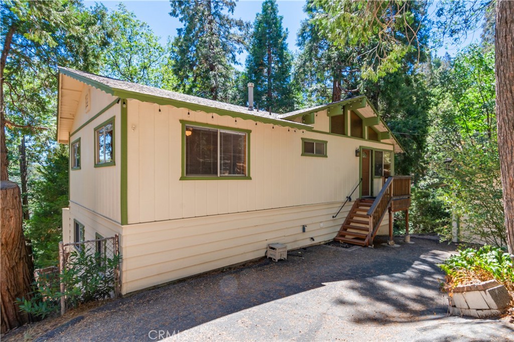 Crestline Mountain Retreat with Beautiful Views, Space & Character Welcome to your ideal mountain getaway in the heart of Crestline! This inviting 4-bedroom, 3-bathroom home offers 1,600 sq ft of flexible living space with breathtaking views, nestled on a rare double lot (17,125 sq ft / .39 acres) surrounded by mature trees and natural beauty. Built in 1976, this well-maintained home blends rustic charm with modern updates. The open-concept main level features a bright and airy living space, large windows, wood-burning fireplace, and an updated kitchen with a breakfast bar that flows into the dining area. Step outside onto your spacious wood deck and soak in panoramic views of the San Bernardino mountains—perfect for morning coffee or evening entertaining. The home offers two light-filled bedrooms on the main floor that can be used as guest rooms. The primary suite is tucked away on the lower level, featuring an en-suite bath and two closets, including a cedar lined closet. Also on the lower level is a cozy family room, a guest room, a laundry area, an additional bathroom, and a versatile unfinished bonus room—ideal for a storage space, workshop, den, craft or sewing room, or even a future granny flat or studio apartment. Additional features include: 4 bedrooms | 3 bathrooms (1 full, 2 three-quarter) Detached tandem garage with built-in workbench Wood-burning fireplace for cozy winter nights Recently upgraded flooring on the main level Extra parking on a peaceful cul-de-sac—perfect for guests Furnishings may be negotiable for a turnkey experience Close to hiking, Lake Gregory, and charming Crestline shops and dining Whether you’re searching for a peaceful full-time home, a weekend getaway, or an investment with potential, this Crestline charmer offers space, privacy, and classic mountain appeal. Don’t miss this unique opportunity—schedule your private showing today! Extra parking in cul-de-sac. Furnishings may be negotiated.