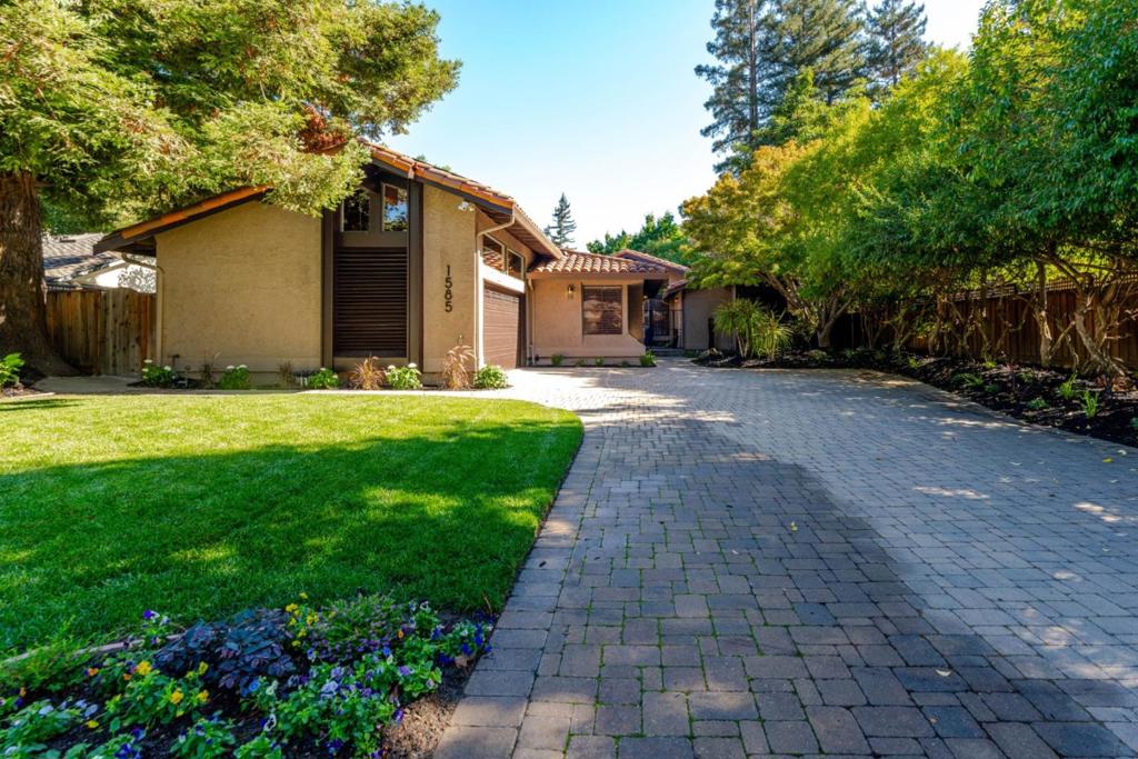 Serene Contemporary Retreat! Set discreetly back from the road and behind a lush green lawn you are greeted by a soothing bronze water feature and gated entry courtyard with a Zen-like serenity that extends throughout the home. Soaring ceilings, a wealth of windows and skylights, grand scale rooms, tastefully updated bathrooms and kitchen all convey a sense of refined elegance in this sophisticated home. Step into the backyard and enjoy nature's embrace with complete privacy, majestic oak trees and well tended landscape. This special home features a generously sized master suite with a sumptuous, spa-like bathroom on one side of the house and three additional bedrooms on the other. Additional amenities include a sunken wet bar with wine refrigerator and wine display closet, custom light-filtering window shades, walk-in custom closets, owned solar system, water purification system, premium garage flooring, a generous amount of storage cabinets in the garage and a Tesla charging station. Excellent Los Altos schools and close proximity to shopping and dining. With comfort and luxury in mind, every detail has been carefully considered in this extraordinary home.