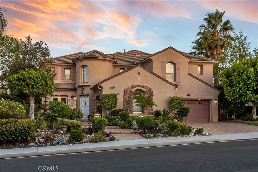 Welcome to this Executive Pool Home, perfectly situated in the prestigious Torcello tract at the top of Stevenson Ranch. A picturesque tree-lined street leads you to this stunning home with incredible VIEWS and curb appeal. A private courtyard with a grand fountain, beautifully pavered driveway and walk ways sets the tone for the pride of ownership you’ll find throughout. This former model home offers 5 bedrooms, 5 bathrooms, and an impressive 4,124 sq. ft. of thoughtfully designed living space blending elegance, functionality, and comfort. Inside, a grand rotunda entry with soaring ceilings and beautiful Versailles patterned tile welcomes you. Natural light pours in through oversized windows, highlighting the inviting paint selections and open layout. The chef’s kitchen is a true centerpiece, featuring abundant cabinetry, huge center island, granite counters and backsplash, a stylish light fixture, butler’s pantry, and walk-in pantry. Entertain with ease in the formal living and dining rooms, both with views of the lush landscape, or relax in the family room with its custom built-in media center, elegant fireplace, and views of the backyard. The main level also offers a private guest suite with ensuite bath, a home office with custom built-ins, a powder room with designer wallpaper, a large laundry room, and generous storage. Upstairs, the luxurious primary suite is a true retreat with sweeping mountain views, two walk in closets with custom organizers, and a separate lounge area perfect for a sitting room, office, or gym. The spa-like ensuite bath boasts dual vanities, a makeup area, soaking tub, and walk-in shower. Three additional bedrooms are generously sized, two sharing a Jack-and-Jill bath and one with its own ensuite. A spacious loft provides the ideal spot for a media room, playroom, or additional office space. Step outside to your private backyard oasis with incredible views of the surrounding mountains and landscape. The resort style pool with cascading waterfalls, elevated spa, sitting area, and covered patio create the perfect setting for relaxing evenings or weekend gatherings. Ample side yards provide room for pets and gardening. Additional modern conveniences include solar panels, a solar-heated pool, a brand-new HVAC system, and a three car garage with built in storage. Located near award-winning schools, scenic parks, shopping, and with easy access to the 5 freeway, this exceptional residence offers the best of Stevenson Ranch living.