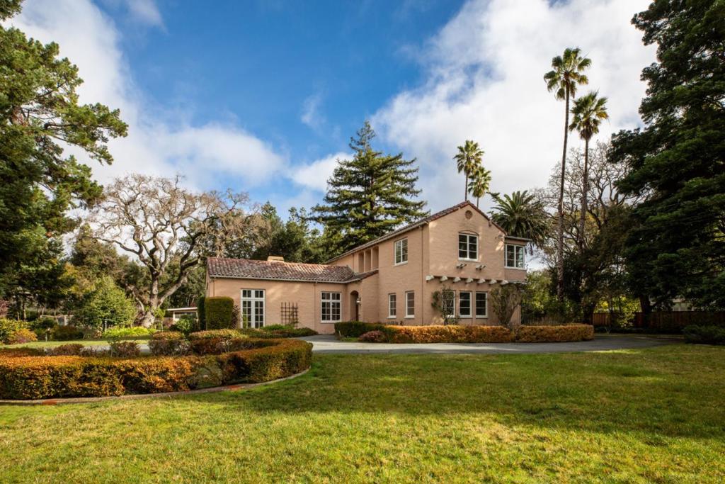 Situated on a fantastic street in the heart of West Atherton, the country's most exclusive ZIP code, this property awaits a vision for the future. The expansive, fully level lot spanning more than one acre also presents an enticing opportunity for new construction in this prestigious location with proximity to many magnificent estate properties. Within the main residence, classic details resonate throughout with, original hardwood and tile floors, and a focal point carved stone fireplace in the grand living room. The kitchen is vintage with its tiled counters metal cabinetry and a sun room opens to the rear grounds. Completing the main level are a den, a generously sized bedroom with an adjacent bath, a half-bath, and a laundry room with steps leading down to the partial basement. The upper level reveals a bedroom suite, a office, a large bedroom with an adjoining office, and a bath. Encompassing approximately 1.136 acres, including a mid-century style pool cabana with wet bar, elevated fireplace, floor-to-ceiling wall of glass. A covered lounge, along with a changing room and full bath, is located at the opposite end of the pool. Additionally, there is a multi-room apartment with kitchen and bath situated above the detached 2-car garage. Lush mature perimeter landscaping.