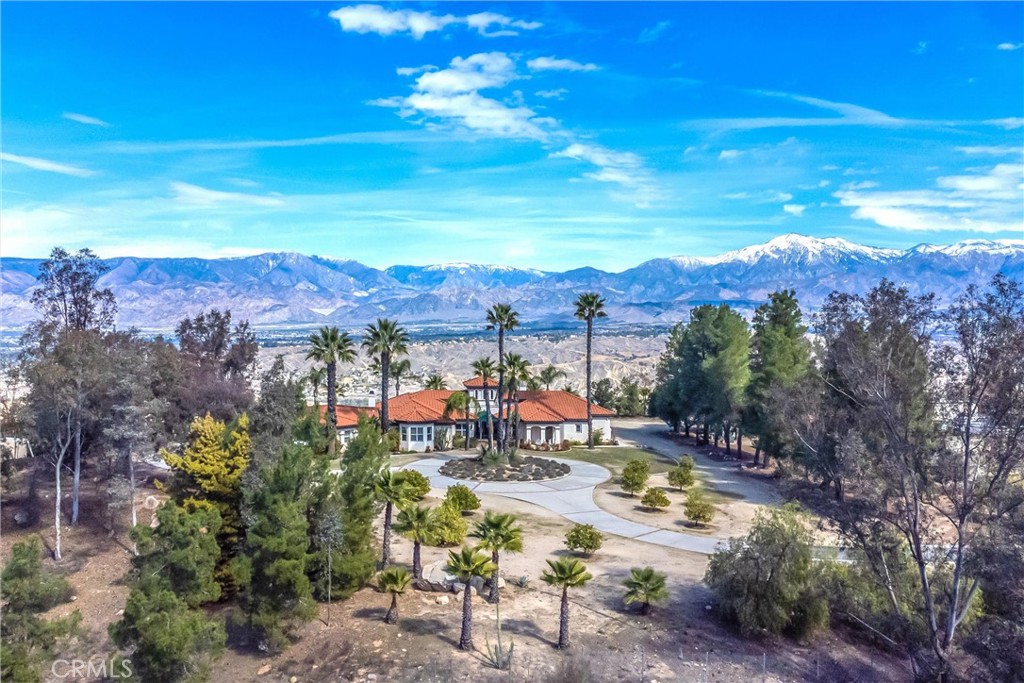 Nestled on a sprawling 10.85 acre estate in the prestigious gated community of Tremont Ranch, This stunning Mediterranean-style home offers unparalleled views of Redlands, San Timoteo Canyon and surrounding mountains. Built in 2000, this single story home boasts 4 bedrooms, 3 baths, and 3034 sqft of luxurious custom living space. The estate includes a 4 car attached garage, and a 1500 sqft detached garage with a lift. Perfect for the car enthusiasts, and for the horse lovers there is a corral. Enjoy your own private well, 22 mature fruit trees, and a sparkling poolside retreat with breathtaking canyon views. This home has an updated HVAC unit, 220v hookups and cleanout for your RV, and the home is renovated with a whole house plumbing re-pipe.
Work at home with an office/library. The entire home has custom mahogany wood cabinetry. The spacious primary bedroom suite includes sitting area and bathroom with shower, and jetted tub. Solid wood doors wider than standard are throughout the home. Lincoln pavers and wood flooring elevate the interior with custom textured walls. Plantation shutters and ceiling fans are in all bedrooms. The kitchen has granite countertops and backsplash, with views of the pool. Fireplaces are in the den and living room for those chilly nights.
This home can be sold fully furnished offering a move-in-ready experience. This custom home provides ample room to grow on this expansive estate. Whether you are sipping coffee poolside overlooking the canyon, or picking fruit from your trees, this South Redlands haven combines luxury, privacy, views for days and natural beauty in one extraordinary package. Don't let this one get away!