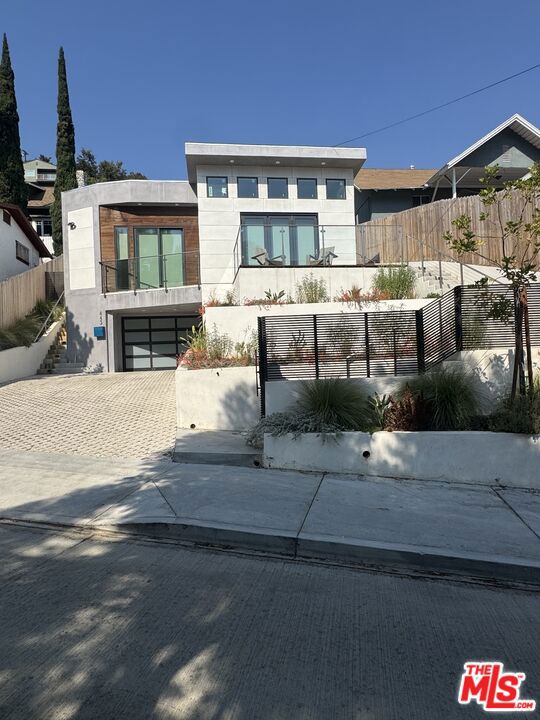 Located in the prestigious Mount Washington neighborhood, this unique estate features two stunning homes on one lot, offering a total of 5 bedrooms and bathrooms. The main home includes 3 bedrooms, 5 bathrooms, kitchen with high-end appliances, and energy-efficient features like solar panels, Tesla inverter, and a tankless water heater. The home also boasts a temperature-controlled wine cellar, multiple balconies with breathtaking views, and an outdoor kitchen with a zero-edge pool perfect for entertaining. The newly built ADU includes 2 bedrooms, 2 bathrooms, and soaring 16-foot ceilings. It opens to a large deck for seamless indoor-outdoor living. The kitchen is equipped with premium appliances, and the unit has a private driveway, garage, and EV charger, making it perfect for guests or tenants. This rare property offers endless possibilities as a family compound or an investment opportunity in one of L.A.'s most sought-after neighborhoods.