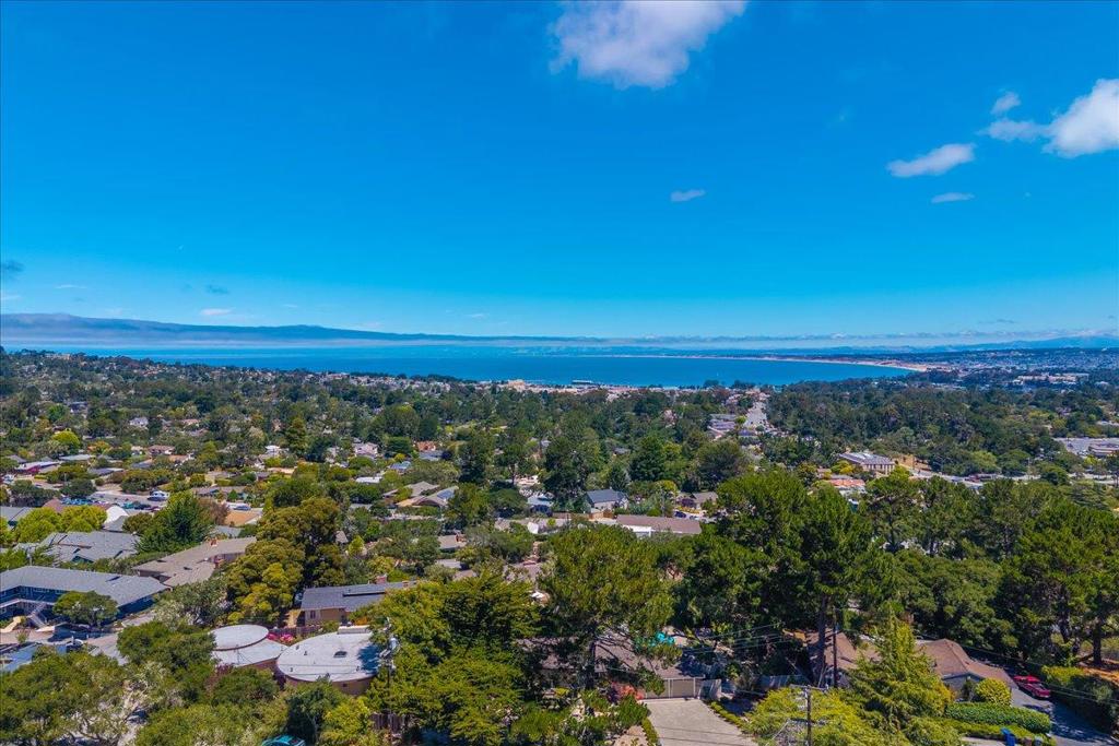 Beautifully updated 2-bedroom, 1.5-bath, quiet end-unit condo featuring panoramic views of Monterey Bay and the surrounding forest. This light-filled home boasts vaulted tongue-and-groove wood ceilings, hardwood floors throughout, and extra windows exclusive to this unit. The open concept kitchen offers granite counters, a gas range, and abundant cabinet space. Enjoy seamless indoor-outdoor living with a private balcony and patio, plus a serene semi-private front porch. Includes two parking spaces in the underground garage and a storage area. Ideally located within walking distance to Whole Foods and Elroys Fine Foods, and just minutes to beaches, scenic trails, dining, and shopping. Perfect as a coastal retreat or full-time residence.