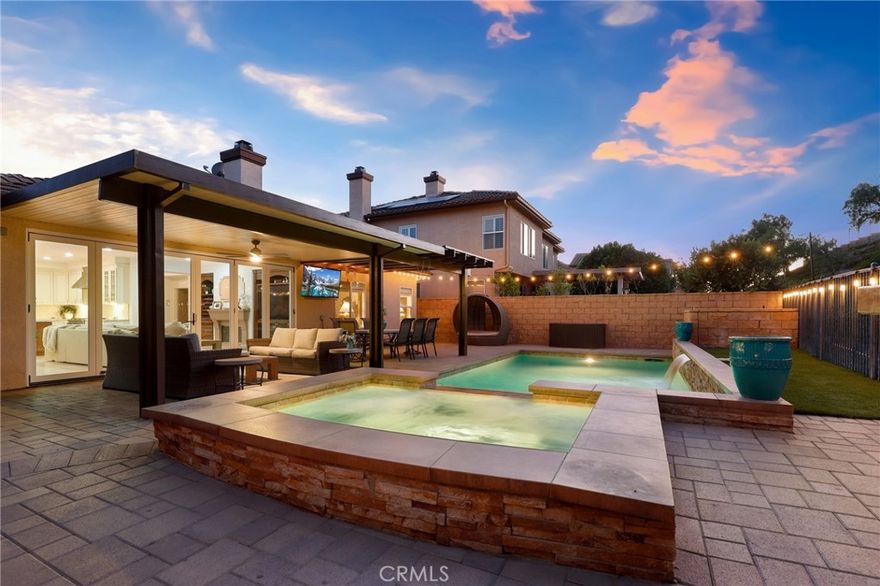 Gorgeous SINGLE-STORY luxury estate with a pool, perfectly situated on a cut-de-sac in one of the area's best locations, on a premium oversized lot in the scenic hills of Serrano Heights. You'll love coming home to this stunning BELLAGIO model, featuring over $400,000 in high-end upgrades that offer the ultimate in style and comfort. Step into the front courtyard, where a charming fountain sets the tone and invites you into a beautifully finished home filled with refined finishes and a lifestyle thoughtfully crafted to capture your heart and imagination. This 3-BR/2.5-BA home includes a custom primary suite where the original fourth bedroom was combined with the third to create an expansive suite retreat, complete with dual walk-in closets and a beautifully remodeled en-suite bath—easily converted back to a four-bedroom. The gorgeous formal living and dining rooms, complete with a butler's pantry, offer an elegant setting for everything from intimate gatherings to lavish celebrations. The family room boasts custom built-ins, a fireplace, surround sound and a striking wall of folding glass doors that highlight incredible backyard views. The show-stopping chef’s kitchen is a masterpiece in itself—equipped with Thermador stainless appliances, built-in refrigerator and wine cellar, gleaming granite counters with stone backsplash, oversized island with ice machine, walk-in pantry and breakfast nook. The luxurious master suite with double-doors, a custom walk-in closet and a spa-inspired bath featuring a jetted soaking tub, stone shower and dual vanities-an ideal space to relax and unwind. And then there’s the backyard—a spectacular outdoor paradise that must be seen to be believed. Nestled on a prized oversized lot, enjoy a resort-inspired backyard with a newly resurfaced saltwater pool, elevated spa and soothing waterfall feature. The beautifully landscaped backyard is an entertainer's dream space offering the ideal setting for outdoor dining beneath a custom-built Alumawood patio cover, built-in BBQ, fire pit and elegant paver flooring-all designed for intimate evenings or lively gatherings. Luxury extras include wide-plank wood & natural stone flooring, plantation shutters, electric window shades, crown molding, recessed lighting, fire sprinklers, newer pool equipment and a finished 3-car garage complete with built-in cabinetry and a custom stone-accented driveway. An extraordinary opportunity to own a standout property in Serrano Heights! Truly a must-see.