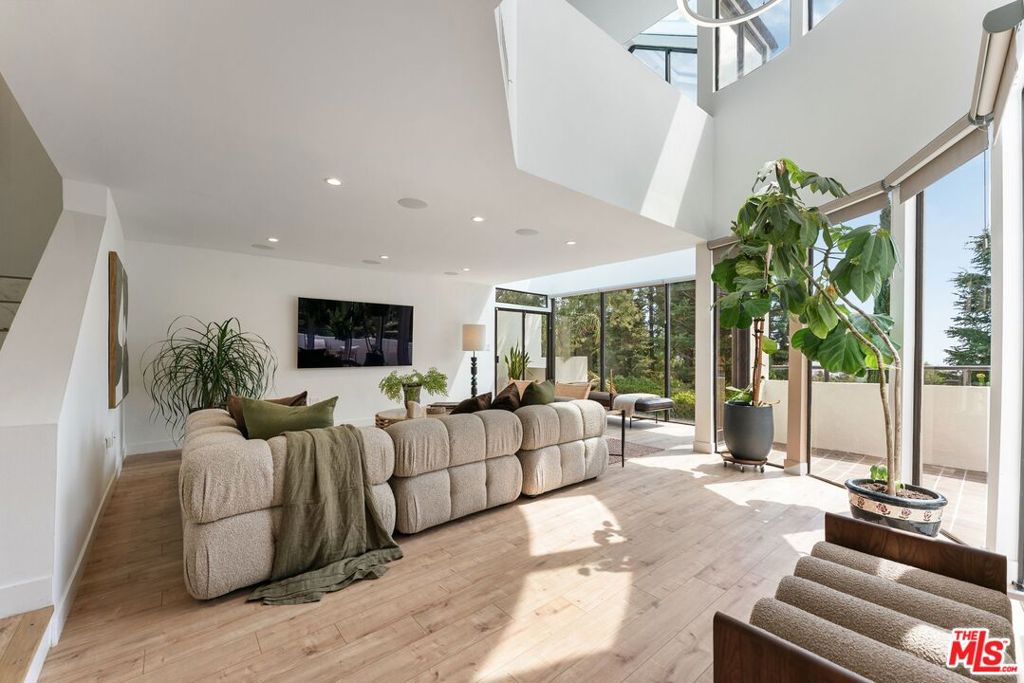 Elevated above the city, this striking modern retreat defines the pinnacle of California living. Floor-to-ceiling glass captures sweeping cityscapes and canyon vistas, while seamless indooroutdoor flow leads to sun-soaked patios, a sparkling pool, and intimate spaces for dining beneath the stars. The chef's kitchen is a true centerpiece, boasting a 6-burner Viking range, custom Dacor built-in refrigerator, new cabinetry, and generous counter space, designed to inspire both culinary creativity and effortless entertaining. On the second level, an expansive living room opens to multiple terraces, each offering breathtaking views and creating an ideal setting for gatherings large or small. A versatile office doubles as a media room, providing both functionality and style for modern living. Upstairs, the primary suite is a serene sanctuary, anchored by a fireplace and framed by gracefully curved windows that showcase the glittering downtown skyline. The spa-inspired ensuite features dual sinks, a rain shower, and a spacious walk-in closet, perfectly blending luxury with comfort. Two additional bedrooms are bright and generously proportioned, including one with direct access to the sun-drenched, solar-heated pool. Every detail has been meticulously considered: smart lighting and shades, Multiple zoned SONOS home audio, CAT 5 Wiring, 240v EV charging, and refined finishes throughout. This home is for the discerning buyer who seeks sophistication, privacy, and effortless access to Los Angeles' finest dining, shopping, and cultural experiences. Fireplaces are strictly decorative.