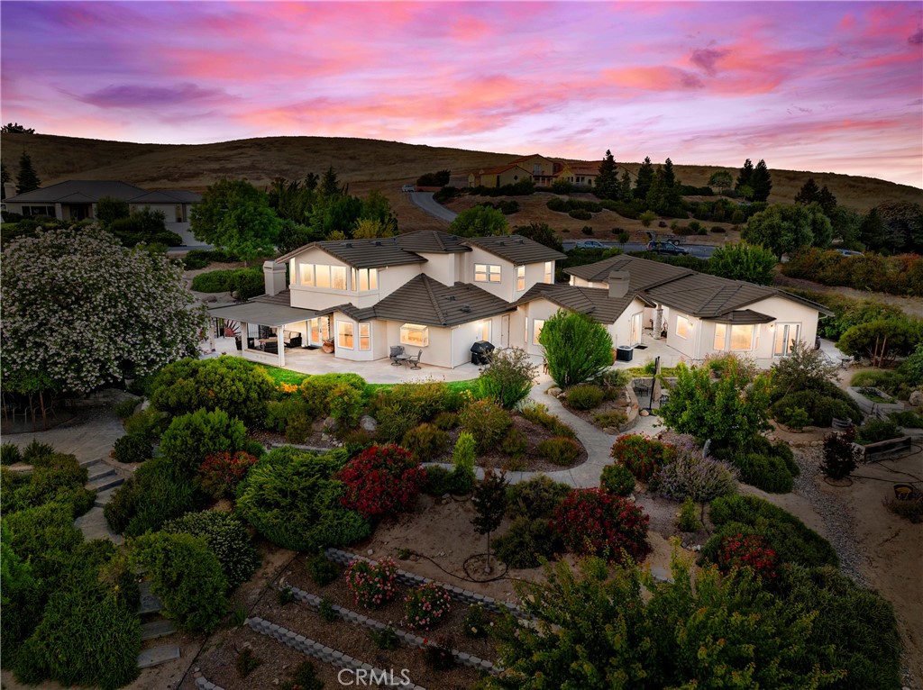 Welcome to this beautifully transformed 4-bedroom, 4-bathroom estate offering 3,221± sq. ft. of thoughtfully updated living space in the coveted gated community of Spanish Lakes—where privacy, security, and refined style meet. The extensive interior remodel and sweeping views from the fully fenced and landscaped one-acre yard create the feeling of a peaceful sanctuary. The main residence features 3 bedrooms and 3 full baths with an open-concept layout enhanced by all-new LVP and tile flooring on the main level, custom stairway banisters and treads, new interior doors and hardware, and a striking stone fireplace with wood mantle. The gourmet kitchen has been thoughtfully upgraded with a Wolf range/oven, Subzero refrigerator, upscale finishes, and a new front door, paired with a functional Ring security system and Wi-Fi controlled thermostats for peace of mind. The primary suite offers a spa-inspired bath with a freestanding tub, glass-enclosed shower, and custom closet built-ins. Additional updates throughout the home include fresh interior paint, upgraded ceiling fans, and a laundry room featuring a Wash Tower with built-in cabinetry. Beyond the main house, the spacious guest house has been refreshed and includes a full kitchen, living room, large bedroom with walk-in closet, and a full bath—ideal for family, guests, or multi-generational living. The home also benefits from owned solar, a new furnace (for both the main house and guest house), and a Culligan water filter exchange system. Exterior improvements include significant roof, fascia, and gutter repairs, repainted trim, a brand-new Wi-Fi-enabled irrigation system, newly constructed garden steps, and concrete block shoring for enhanced landscaping. The garage includes a convenient utility sink. Set on a fully fenced and meticulously landscaped property with fruit trees and raised garden beds, this exceptional home offers luxurious interiors, modern systems, and serene outdoor living—all nestled in one of Paso Robles' most sought-after communities where scenic tranquility meets everyday convenience.