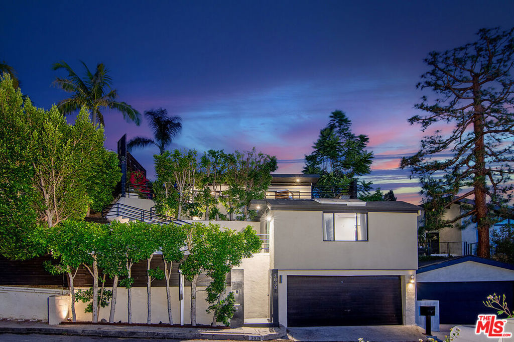 High above vibrant Ventura Boulevard, this gated Studio City retreat offers a harmonious blend of peaceful seclusion and the lively pulse of city life. This mid-century modern compound, featuring the desirable combination of a 3-bed/2-bath primary residence and a fully detached, permitted 1-bed/1-bath ADU, provides remarkable adaptability with stunning panoramic views that sweep across the horizon. Inside, the main residence radiates timeless charm: hardwood floors beneath carved wood accents, clear glass doors, and modern fixtures that blend rustic warmth with sleek style. The eat-in kitchen and refreshed primary suite open to a spacious, private backyard and deck, creating an inviting space for gatherings or quiet repose. From the front terrace, a modern glass fire pit sets the scene for the glow of northwestern sunsets or the city's twinkling skyline. The detached guest house features warm Douglas Fir floors, a compact kitchenette, and a stylish 3/4 bathroom, offering a flexible haven for guests, creative pursuits, or a calm workspace, all framed by captivating views. Nestled within the esteemed Carpenter School District and moments from CBS-Radford, fine dining, and vibrant LA life, this hillside sanctuary weaves light, air, and timeless beauty into a warm retreat where dreams find their home.