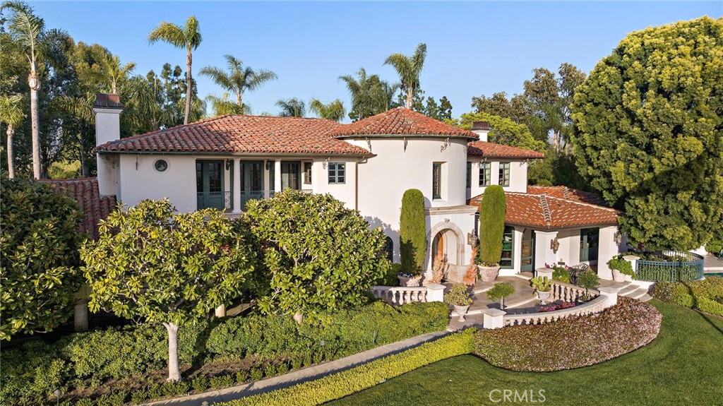 Welcome to the Crown Jewel of Lemon Heights!
Tucked behind gates and unapologetically perched atop North Tustin’s most coveted ridge, this 1930s Mediterranean Revival estate isn’t just rich in history—it’s dripping in it. Set on two landscaped parcels totaling 2.4 acres, this iconic residence is as timeless as it is commanding.
The setting? Next level. Unobstructed views sweep from Catalina to Palos Verdes, then pivot to reveal pastoral hills and snow-capped mountains. And while most hilltop properties trade flat land for the skyline, this one breaks the rules—serving up lush, expansive lawns and cinematic vistas.
The estate has been under the careful eye of a single family for nearly 30 years, and it shows. Every inch of the 6,500-square-foot main house whispers craftsmanship: soaring ceilings, hand crafted stucco walls, antique walnut woodwork, and European-carved stone mantels that practically demand candlelight and jazz.
But this isn’t just a home. It’s a compound. Think guest house, carriage house, separate multiple garages, rec center, and a 1,000+ sq ft outdoor veranda made for high-end soirées and impromptu sunsets. Around back? A circular motor court, central fountain, and gardens made for wandering barefoot with coffee in hand.
And just when you think it couldn’t get more romantic—cue the infinity-edge pool and spa, perfectly poised for golden hour over Catalina and glittering city lights by night.
But the final twist? A one-acre, undeveloped California-style garden tucked into the lower lot—ripe for a private vineyard, sculpture garden, or whatever dreamy vision you bring to the table. Framing it all: a canopy of over 90 trees standing 50 feet tall or more, with dozens more forming a lush, whisper-quiet buffer from the world.
Historic. Iconic. Irreplaceable.
You don’t find estates like this—you inherit them.