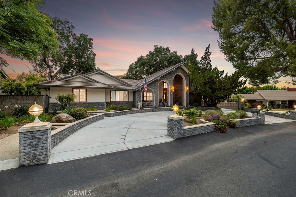 Private Multi-Generational Estate with Nine-Car Garage & a Sprawling lot in the Mountain Springs Gated Community. Situated on a quiet cul-de-sac in the prestigious Mountain Springs Gated Community with multiple 100+ year old oak trees, this remarkable estate is the epitome of space, privacy, and refined living. Framed by manicured landscaping, the home welcomes you with a brand-new sweeping circular driveway–with a gated motor court that leads to a fully finished nine-car garage, complete with a workshop, attic storage, and a private gym. The triple arched, covered front patio sets the tone for timeless elegance. Step inside to a tile-floored foyer that opens to a formal living room adorned with a brick fireplace–perfect for intimate gatherings. Vaulted tongue-and-groove ceilings with exposed beams add warmth and volume to the spacious family room, which features a striking floor-to-ceiling stone fireplace and seamless connection to the kitchen. Custom oak cabinetry, a center island, and charming brick accents define the heart of the home, while an adjacent formal dining room with chandelier captures scenic views of the backyard. Designed for both work and leisure, the main level offers a detailed wood-paneled library, a large executive office with hardwood floors, and a powder room. The primary suite is a true retreat, complete with a private sitting area, French doors to the backyard, and a luxurious remodeled bathroom with vaulted ceilings, tiled accent walls, dual vanities, a jetted tub, frameless glass walk-in shower, and a finished walk-in closet. Three additional bedrooms and a remodeled hall bath are located on the main level, along with a spacious laundry room equipped with cabinetry and a utility sink. The lower level is an entertainer’s dream—a grand gathering space with rich custom millwork, another floor-to-ceiling stone fireplace, a full wet bar, and French doors that frame panoramic views of the pool and expansive backyard. This level also includes an additional guest bedroom with en-suite bathroom. Outside, the backyard is a private sanctuary beneath a canopy of mature oak trees, featuring a sparkling pool and spa, flagstone decking, tiered planters, open lawn, winding pathways, and a large view deck that extends from the main level—perfect for entertaining or quiet sunset evenings. Brand new roof underlayment completed less than a year ago. Reimagine this home with your own finishes and get the best value price per ft. on the market today.