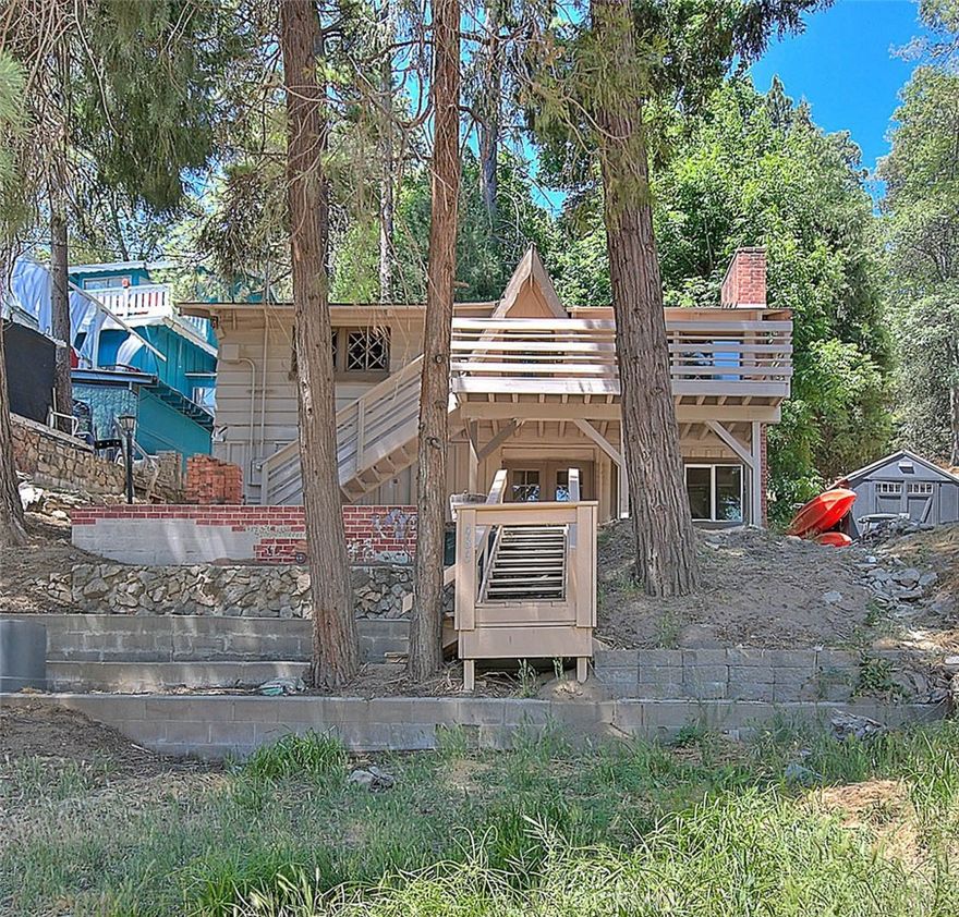 Nestled in the peaceful mountain community of Crestline, this inviting two bedroom, two bathroom home offers, comfort, space, and classic charm. The home features a cozy fireplace on each level perfect for chili Mountain evenings.   Downstairs you'll find a spacious living room, ideal for relaxing or entertaining, a full bathroom and a large laundry room for your convenience. There's also a versatile workshop area great for hobbies or additional storage.  Upstairs, two generously sized bedrooms, sharing a second floor bathroom, offering plenty of space for families or guests. Step into warmth and character with this inviting cabin style home featuring stunning bolted, wood beam ceilings that create an airy, open atmosphere in the living and kitchen area. The rich, natural wood accents draws your eyes upward, making the space feel expansive and full of light. A cozy stone fireplace anchors the room, perfect for relaxing evenings. The open floor plan includes a central island and dining space ideal for gatherings, all set against beautiful wood flooring that enhances the rustic charm. Whether you are looking for the full-time home or a peaceful getaway, this property blends, comfort with cabin elegance in every corner.  Minutes from Lake Gregory.  additionally, it offers hiking trails and access to local parks.  The property is being sold as-is and requires minor repairs and TLC.