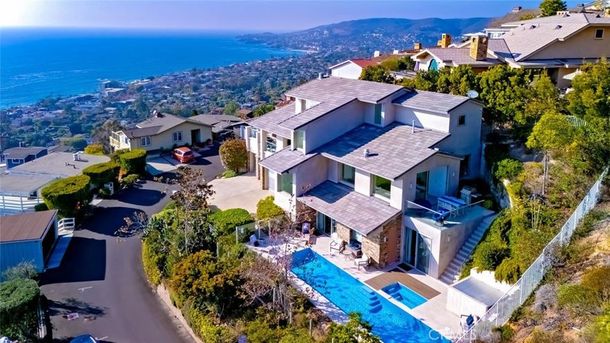 Breathtaking views with sunsets over Catalina Island to glittering city lights and sweeping whitewater views, this custom soft-contemporary residence captures the very best of Laguna Beach living. Showcasing dramatic ocean panoramas from nearly every room and terrace.  Thoughtfully crafted for both grand entertaining and intimate relaxation, the home’s outdoor spaces include multiple ocean-view decks, a spacious terrace with a saltwater pool and spa, an expansive patio extending from the great room, and a private balcony off the primary suite—each offering an unforgettable coastal backdrop.  A frameless glass entry door introduces a sophisticated interior, encompassing four bedrooms and four and a half baths, a striking stone-accented foyer, with high ceilings, floor-to-ceiling windows, whole-house audio, and three fireplaces create an atmosphere of modern refinement and effortless elegance.  Designed by award-winning architect Joseph Ambrose, the residence exemplifies impeccable craftsmanship and timeless contemporary design. The main entertainment level centers around a dramatic great room and a sleek chef’s kitchen appointed with custom European-style cabinetry, a waterfall island with bar seating, stone surfaces with full-height backsplash, and professional-grade stainless-steel appliances including a built-in refrigerator and 6-burner cooktop.  The ocean-view primary suite is a private retreat unto itself, offering vaulted ceilings, dual custom closets, and a spa-inspired bath with a soaking tub and oversized shower—an idyllic sanctuary where modern luxury meets coastal tranquility.