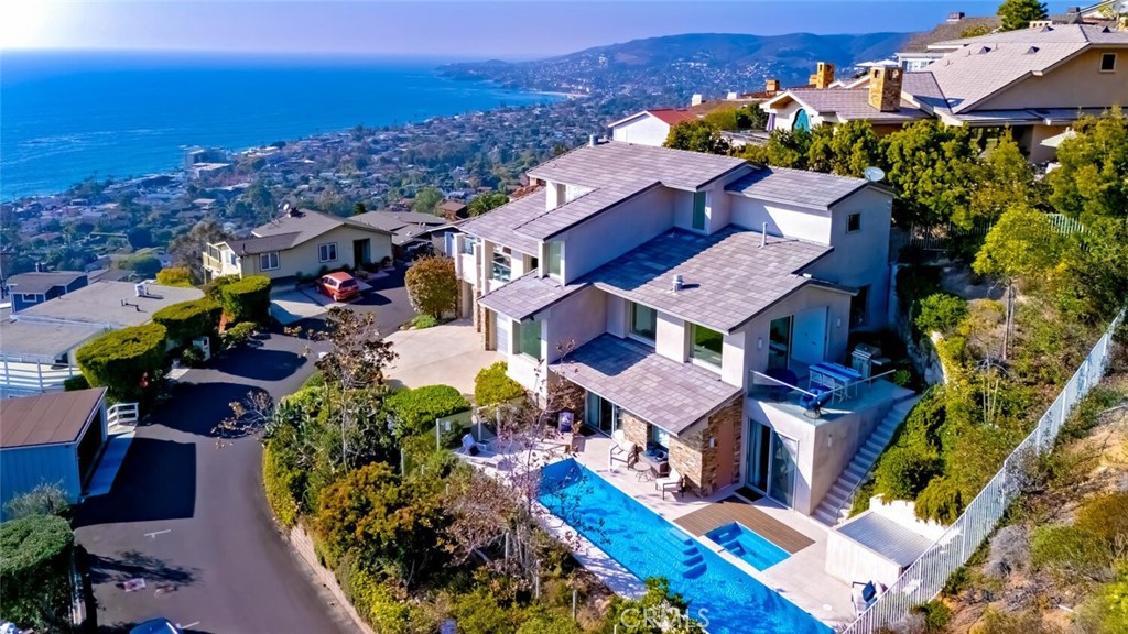 Breathtaking views with sunsets over Catalina Island to glittering city lights and sweeping whitewater views, this custom soft-contemporary residence captures the very best of Laguna Beach living. Showcasing dramatic ocean panoramas from nearly every room and terrace.  Thoughtfully crafted for both grand entertaining and intimate relaxation, the home’s outdoor spaces include multiple ocean-view decks, a spacious terrace with a saltwater pool and spa, an expansive patio extending from the great room, and a private balcony off the primary suite—each offering an unforgettable coastal backdrop.  A frameless glass entry door introduces a sophisticated interior, encompassing four bedrooms and four and a half baths, a striking stone-accented foyer, with high ceilings, floor-to-ceiling windows, whole-house audio, and three fireplaces create an atmosphere of modern refinement and effortless elegance.  Designed by award-winning architect Joseph Ambrose, the residence exemplifies impeccable craftsmanship and timeless contemporary design. The main entertainment level centers around a dramatic great room and a sleek chef’s kitchen appointed with custom European-style cabinetry, a waterfall island with bar seating, stone surfaces with full-height backsplash, and professional-grade stainless-steel appliances including a built-in refrigerator and 6-burner cooktop.  The ocean-view primary suite is a private retreat unto itself, offering vaulted ceilings, dual custom closets, and a spa-inspired bath with a soaking tub and oversized shower—an idyllic sanctuary where modern luxury meets coastal tranquility.