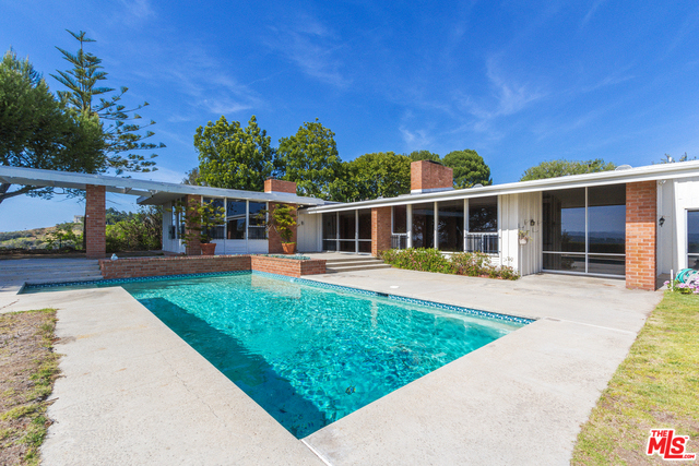 Expansive panoramic city lights, ocean and canyon views! Ideal development opportunity on this perfectly sited half-acre promontory in coveted Trousdale Estates in Beverly Hills. The existing Mid-Century home features 4 bedrooms, 4.5 bathrooms, spacious public rooms with high ceilings, impressive volume, walls of glass, a massive motor court and a large private yard a with pool. Situated to take in stunning canyon, ocean and city views, let your imagination run wild with the possibilities this home presents to remodel, redevelop or build your dream estate. A rare opportunity in one of the city's most desirable enclaves! Trust sale, no court confirmation required. Contact listing agent for Buyer's Package.