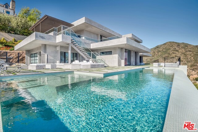 A rare modern architectural masterpiece with spectacular whitewater ocean views. This compound has it all, including an address in one of the few private neighborhood enclaves with deeded beach rights and pathway traversing under PCH providing access to coveted Escondido Beach. The main estate sits behind private gates with a living koi pond entry exterior hallway, ascending to the 2nd level foyer - offering spectacular sweeping whitewater ocean views upon entry. An open floor plan, ideal for entertaining, boasts floor to ceiling walls of glass opening to large patios, fire pits and seating areas. High ceilings invite in abundant light to flood the chef's kitchen and fully-equipped bar and outdoor kitchen. A pool, spa, N/S tennis court, and guest house with separate entrance complete this rare offering. Price includes the Rolls Royce in the garage.