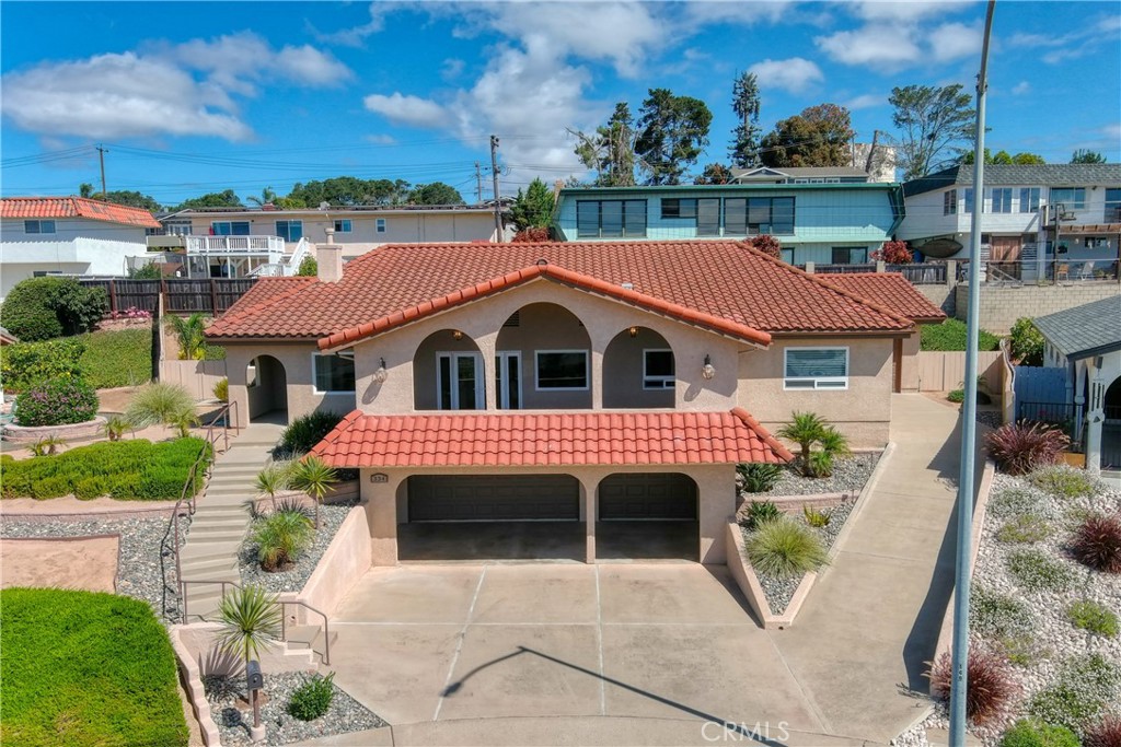 Welcome to 334 Corona del Terra, Arroyo Grande
Perched high on the hillside at the top of a quiet cul-de-sac, this elevated residence offers a vantage point rarely found in Arroyo Grande. From nearly every room and the spacious balcony, you are greeted with panoramic ocean views that stretch endlessly by day and transform into breathtaking sunsets and glittering city lights by night. The setting creates a living experience that feels both serene and inspiring, blending coastal beauty with hillside privacy.
Step inside and discover a home designed for both comfort and entertaining. The open-concept floor plan showcases soaring ceilings, premium flooring, and a soothing neutral palette that complements the natural light pouring in. The chef’s kitchen is a centerpiece with custom cabinetry, under-cabinet lighting, Frigidaire appliances, and dramatic granite countertops—perfect for preparing meals while still being connected to the living and dining spaces. A bonus room off the main living area makes an ideal media lounge or entertainment hub for movie nights.
The primary suite is a true retreat, offering abundant space for a sitting or reading nook, a custom walk-in closet, and a spa-like bath. With a floating dual vanity, dimmable under-cabinet lighting, a soaking tub, skylight, and elegantly designed shower, it’s the perfect place to unwind. Two additional guest en-suites provide both comfort and privacy, while a total of three full baths and two half baths accommodate gatherings with ease.
Car enthusiasts and entertainers alike will appreciate the rare four-car garage configuration: an oversized single bay plus an oversized three-car garage with fresh epoxy flooring. Just beyond is a unique “secret room” with thick walls, once used for music practice, offering a creative space for hobbies, workouts, or a private retreat.
This home is equally suited to lively entertaining or quiet evenings at home. The balcony becomes a natural gathering space, where guests can enjoy coastal breezes, golden sunsets, and the magical glow of the city lights below. At night, the professionally designed landscape comes alive with automatic garden lighting, extending the ambiance outdoors.
Blending thoughtful design, modern amenities, and a lifestyle defined by unmatched views, this home is more than a residence—it’s an experience you’ll want to call your own.