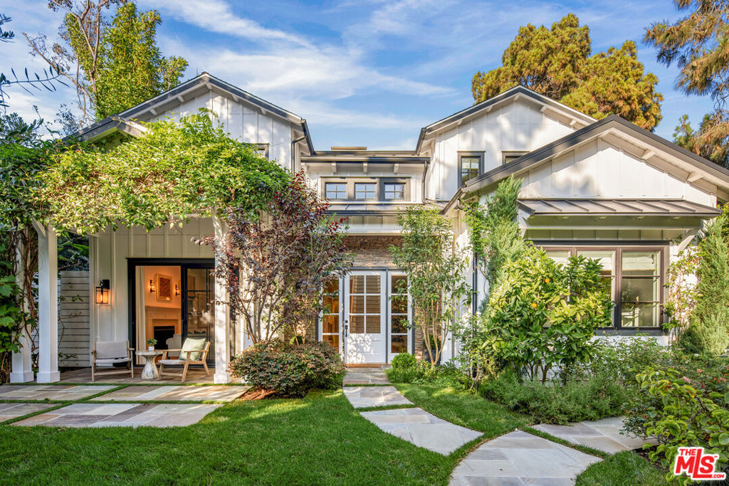 In Santa Monica's coveted North of Montana neighborhood, this stunning designer home with interiors by Natasha Baradaran showcases unparalleled sophistication and comfort. Lush landscaping, including mature hedges and olive trees, creates a secluded, park-like atmosphere as you approach the property. A grand two-story entry with a statement chandelier welcomes you, leading to a well-appointed main level. Here, you'll find a dedicated office space, a guest bedroom with an ensuite bathroom, a formal living room with a fireplace, and a sophisticated dining area with views of a picturesque outdoor waterfall. The spacious kitchen is outfitted with Wolf and Miele appliances, complemented by a wet bar for entertaining and a butler's pantry for extra space and convenience. An inviting family room opens to the back porch, offering indoor-outdoor living with a covered patio, featuring heaters, a gas fireplace, a built-in BBQ area, and plenty of green space. The second story of this house is illuminated by generous skylights, leading to four additional ensuite bedrooms. The upper level also houses a versatile family room/den and a convenient laundry room. The expansive primary suite is a true retreat, featuring beamed ceilings, a gas fireplace, and a balcony overlooking the backyard. Two spacious closets and a luxurious bathroom with dual vanities, a large soaking tub, and a glass-enclosed shower complete this personal sanctuary. Thoughtful details curated by Baradaran include custom wallpaper, bespoke light fixtures, and carefully selected window treatments. High-beamed ceilings enhance the sense of spaciousness throughout. This exceptional property is ideally located near lively shops and restaurants of Montana Avenue, the Brentwood Country Mart, and Santa Monica's renowned beaches. With its generous living spaces, five bedrooms, and more than 5,000 square feet of interior space, this residence offers the pinnacle of Santa Monica living.