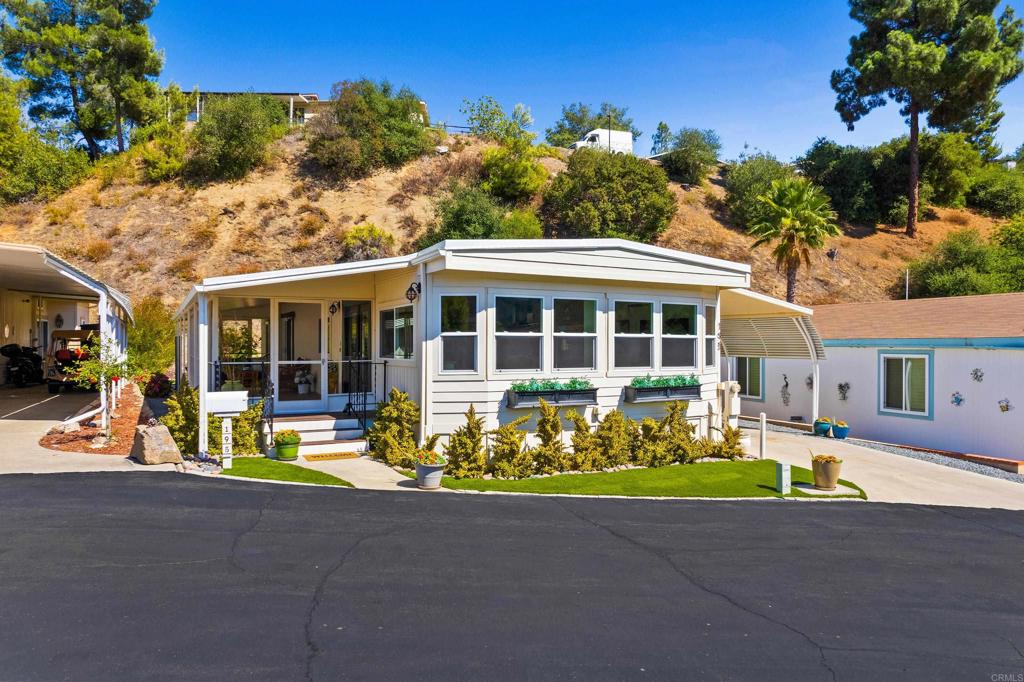 LAND OWNED premier luxury property in Lawrence Welk’s Champagne Village! Tucked away at the end of a quiet cul-de-sac, this beautifully updated 2-bedroom, 2-bath home offers privacy and breathtaking panoramic mountain views. From the main living room to the sunroom, enjoy serene living surrounded by natural landscapes. The stylish kitchen features updated stainless appliances, butcher block counters, and ample storage. Comfort is maximized with individually controlled mini-splits in the main living room and bedrooms. The bathrooms have been refreshed, including a newly renovated guest bathroom walk-in shower with updated plumbing, along with new copper piping throughout the home. Both the main roof and sunroom roof have been replaced for peace of mind. The property has been thoughtfully landscaped with artificial turf, new irrigation, and thriving peach, tangerine, lemon, and orange trees, creating a private backyard oasis. A lighted, insulated shed provides the perfect space for extra storage. Champagne Village, a premier 55+ community, offers resort-style amenities including a clubhouse with regular social events, pool, tennis, pickleball, and perks at the Lawrence Welk Resort. With easy freeway access to both San Diego and Riverside Counties, this home blends comfort, convenience and community.