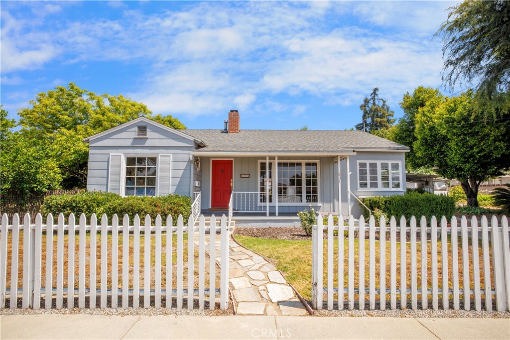 Welcome to 695 W 13th Street, where timeless character meets everyday comfort. Situated on a spacious corner lot, this delightful 1940s grove home offers classic charm, natural beauty, and incredible potential. Step inside to discover original hardwood floors, a cozy fireplace, and a large front picture window that fills the home with natural light. The kitchen maintains its vintage charm with an original stove, perfect for those who appreciate mid-century details. Outside, the entire property is enclosed by a classic white picket fence, creating a storybook setting with a working garden area and mature avocado, lemon, and lime trees. With a rare double lot, there’s plenty of room to expand, entertain, or simply enjoy the outdoor space. A true gem with soul, sunshine, and space….ready to be loved and lived in.