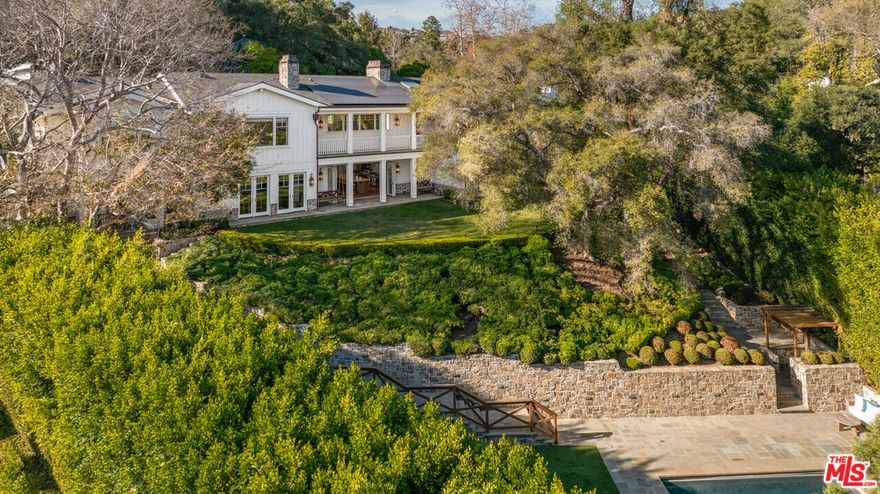 Step behind a discreet gate into a private oasis. A gentle stream sets a calming tone as views open to nearly an acre of park-like grounds. Stone pathways lead to beautiful yards for relaxation and play, a sports court, a gorgeous pool area with spa and guest house. The main residence, reimagined with Maurice Gadson Design, embodies simplicity, beauty, and craftsmanship. The dramatic living room and kitchen with soaring ceilings and seamless garden access are the heart of the home. The custom wood paneled media room and secondary family room were designed for comfort and flexible living. Every detail speaks of curation: Samuel Heath and Waterworks fixtures, vintage French lighting, textiles by Holly Hunt, Thomas Lavin, Schumacher, Missoni runners, Calcutta stone, custom millwork, and Christian Lacroix wallpaper. Smart automation and tailored shades complete the experience. The outdoor kitchen and dining area with views of your very own vineyard elevate one's entertaining experience and evenings by the outdoor fireplace brings birdsong, owl calls, and absolute tranquility. Boca de Canon is a setting that truly cannot be replicated.