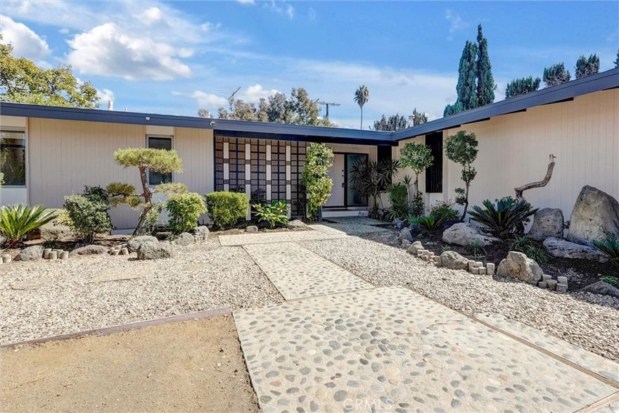 Tucked away on a quiet cul-de-sac, this inviting mid-century residence combines timeless character with a unique, easy-flowing floor plan — perfect for first-time buyers or anyone looking for comfortable single-level living. Nearly 1,700 sq. ft. of living space includes three bedrooms and two baths with freshly redone hardwood floors and paint thoughout. Set on a large, beautifully landscaped lot, the heart of the home is a dramatic living room with pitched ceilings,where floor-to-ceiling glass walls open to a manicured, breezy backyard, creating a true indoor-outdoor connection. The updated kitchen adds everyday functionality, while the bathrooms offer an opportunity to bring your own design vision to life. Subtle Asian-inspired landscaping adds a tranquil touch to the curb appeal, enhancing the serene setting. Located close to North Hollywood’s favorite shops, parks, and freeway access, this home offers comfort, character, and potential—all in a peaceful neighborhood setting, in addition to ADT Security System and off street parks for 4x cars.