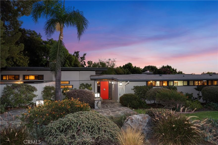 Beautifully landscaped single-story Mid-Century Modern home on over an acre of land! With wonderful mountain and city views, the yard has many fruit trees, including orange, lemon, lime, fig, avocado, apple, and peach. A newer gazebo sits next to the sparkling pool and spa, perfect for outdoor entertaining with outdoor kitchen including BBQ, small refrigerator, lights, and sink. The two-car carport with utility sink, storage cabinets, and EV plug is attached to the house. The house itself has an open floor plan with four bedrooms, including a newer master bedroom suite with wood-beamed ceilings and private patio, a two-sided stone fireplace, and an oversized walk-in closet with a sliding ladder for access to shelves. Master bathroom shares a fireplace with the bedroom and has cherry cabinets with/double granite sinks, a spa tub, and a shower. There are two additional bedrooms in the main house, each with adjacent bathrooms. The fourth guest unit/bedroom with 3/4 bath is on the other side of the carport. The living room and family room have wood-beamed ceilings and share a double-sided stone fireplace. The kitchen has original cabinets with granite counters and a breakfast bar. The property also has a stand-alone office/workshop building and a storage shed.