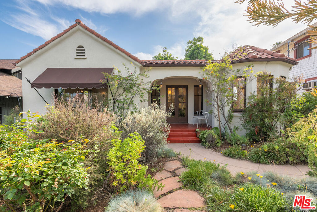 This spectacular 1929 Spanish Revival residence captures the romance and craftsmanship of a bygone era, rich with timeless character and charm. Perched gracefully along the palm tree-lined Avenue 59, the home has been lovingly preserved, showcasing an array of original period details throughout. Step inside to discover a sun-filled formal living space with warm wood floors, elegant barrel ceilings, a decorative fireplace, and an oversized picture window that frames the lush front garden. The formal dining area is perfectly situated with views through French doors out onto the porch and surrounding greenery. The efficient galley kitchen features an OK&M stove and connects to the unbelievably charming breakfast rotunda, which highlights original windows and built-ins. Throughout, you'll find vintage wall sconces, architectural alcoves, and other preserved treasures. Two bright bedrooms exude warmth and the comforting feel of "home" and provide ample closet space. The vintage-style bathroom retains its original tilework and a classic vanity, adding to the home's enduring appeal. The drought-tolerant, fenced front garden offers views of one of Highland Park's most iconic homes and is a gardeners' paradise with native and other varieties of plants. In the rear of the property, a private outdoor retreat awaits, perfect for entertaining with a wood deck, grassy play areas, an epic "catio," and head-on views of Downtown L.A. Additionally, mature fruit trees throughout the property yield pecans, figs, lemons, and loquats. Zoned LARD2, the property offers flexibility with three distinct spaces, ideal for creatives, remote professionals, or those exploring income potential. One of the spaces had previously approved plans for an ADU conversion, offering added versatility. Nestled in the historic core of Highland Park, just blocks from the Metro Gold Line, this is a rare opportunity to own a piece of Los Angeles' architectural heritage. Enjoy unbeatable access to York and Figueroa's vibrant dining scene, lively bars, indie coffee shops, boutique shopping, and the ever-evolving creative culture that defines Highland Park. Nearby highlights include the Arroyo Dog Park, hiking trails in Ernest Debs Park, Dodger Stadium, and a host of iconic Southern California destinations.