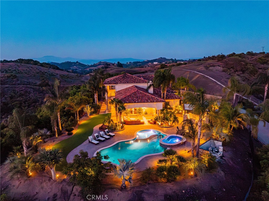 Discover unparalleled luxury and serene country living in this magnificent 4,498 sqft custom-built home, nestled on a secluded 4-acre lot. This architectural masterpiece boasts a GRAND electric gated entry and breathtaking views of the near by De Luz Hills, offering a perfect blend of elegance and functionality.
Key Features:
• Spacious & Modern Design: Soaring 10 ft ceilings throughout, with a grand 14 ft ceiling in the living room. French doors with Clearview screens ensure pest-free ventilation.
• Gourmet Kitchen: Equipped with two Bosch dishwashers, Thermador double oven, microwave, and 6-burner stove for the ultimate culinary experience.
• Luxurious Master Suite: Features two walk-in closets and a spa-like bath with three wide panoramic windows for natural light and stunning views.
• Flexible Floor Plan: Includes two additional main-floor bedrooms connected by a Jack & Jill bathroom, a spacious office with a full bath, and a convenient guest half-bath.
• Entertainment & Comfort: Surround sound system in the master suite, dining room, hallway, and grand room. Lutron Light System controls all exterior and select interior lights via smartphone app.
• Outdoor Oasis: Enjoy a fairly new saltwater Pebble Tech pool with pool lights, an outdoor barbecue and island, and a spacious upstairs balcony showcasing spectacular forest views.
• Oversized 7-Car Garage: Complete with custom cabinets and a utility sink for ample storage and convenience.
• Whole-Home Upgrades: Electrolux central vacuum, whole-house water softener, conditioner, and filtration system, plus a 75-gallon Bradford-White gas water heater. Entire home re-piped with PEX two years ago.
• Pest Protection: Taexx in-wall injectable pest defense system.
• Agricultural Advantage: 360 Haas avocado trees with an agricultural water discount.
This exceptional estate combines modern luxury with the tranquility of country living, all while offering premium features for comfort and convenience. Don’t miss the opportunity to own this one-of-a-kind Temecula retreat! Super close to Old Town Temecula and all of your favorite wineries & restaurants.