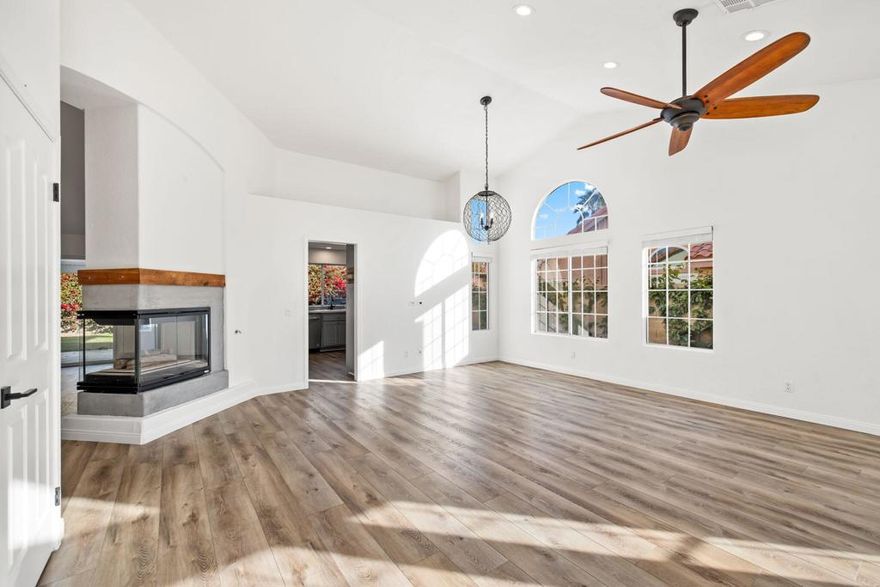 Welcome to this chic desert abode located in the highly sought-after La Quinta Vistas neighborhood. Upon entry, you're greeted by a bright open-concept living and dining area featuring luxury wood-like vinyl flooring and stylish modern lighting throughout. An inviting ambient fireplace subtly separates the living space from the family room, which opens to a well-appointed kitchen with contemporary gray cabinetry, newer stainless steel appliances, and a cozy breakfast nook, perfect for enjoying your morning coffee. The home offers four spacious bedrooms with plush newer carpeting and two tastefully updated bathrooms. The primary suite features dual sinks, a soaking tub, and a walk-in closet for added comfort and convenience. Step outside to an expansive backyard with mature landscaping, ideal for entertaining, complete with a built-in BBQ. Additional highlights include a two-car garage and a laundry room equipped with a newer washer and dryer. Ideally located near shopping, popular restaurants, golf courses, and highly rated schools, this home offers the perfect blend of comfort, style, and convenience.