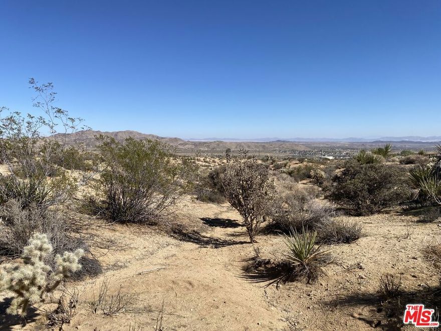 2.62 Acres with Panoramic Views in Upper Friendly Hills. Discover the perfect canvas for your dream retreat on this spectacular 2.62-acre parcel in the highly sought-after Upper Friendly Hills area. Zoned for up to 14 units this prime lot is accessible via a paved road, with a paid water meter already installed and ready for hook up as well as power available nearby, making it easy to begin building right away. Enjoy breathtaking 360 views of the surrounding desert landscape from awe-inspiring sunrises and sunsets to the star-studded night skies that only Joshua Tree can offer. The land offers a serene, private setting, yet remains conveniently close to town amenities in both Joshua Tree and Yucca Valley, and just a short drive to the Joshua Tree National Park entrance. Whether you're envisioning a modern desert hideaway or a peaceful weekend escape, this property combines location, infrastructure, and natural beauty in one of the area's most desirable neighborhoods.