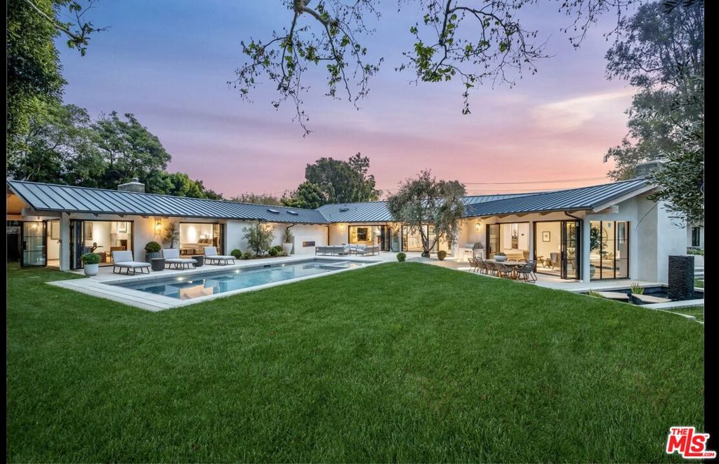 Welcome to this exquisite Scandinavian Ranch, located in the highly sought-after Sullivan Canyon. Upon entering the private double gates, you will be greeted by lushly landscaped grounds that will transport you into a tranquil oasis. This one-story masterpiece has been flawlessly reimagined from top to bottom and boasts four spacious bedrooms, six beautifully designed bathrooms, custom millwork, floor to ceiling doors, vaulted ceilings, and white oak floors throughout. You will be captivated by the open floor plan, featuring a large living room, entertainers bar, formal dining, family room, and secondary dining that all open to the outdoors, creating a perfect space for hosting large gatherings!The gourmet kitchen is flooded with natural light and is equipped with top-of-the-line appliances, large island, and direct access to all communal spaces! Enjoy its exquisite open layout, while looking out onto the full size tennis court! The primary suite is a luxurious retreat, complete with a dual-sided fireplace, private office, and a spa-like bathroom that opens to an outdoor wellness retreat. The other bedrooms are spacious and bright, perfect for guests or family and also open seamlessly to create the perfect indoor/outdoor living experience. Enjoy an array of outdoor amenities including a professionally lit tennis court with a basketball hoop, an 8ft deep pebble pool, and spa. Indulge in the state-of-the-art wellness facility featuring a six-person infrared sauna, premium cold plunge, tranquil meditation platform, and a serene zen pod. The property includes two horse stalls, perfect for keeping your equine friends close to home. The yard is equipped with an outdoor fireplace, built-in barbecue, pool and spa, and a vast koi pond providing a peaceful escape from busy city life. Situated on a sprawling flat lot, this modern ranch masterpiece offers luxury and comfort in equal measure. Designed in collaboration with renowned Montalba Architects who work closely with Nobu Hotels and Soho House. Don't miss the opportunity to make this property your dream home. A must see to believe!