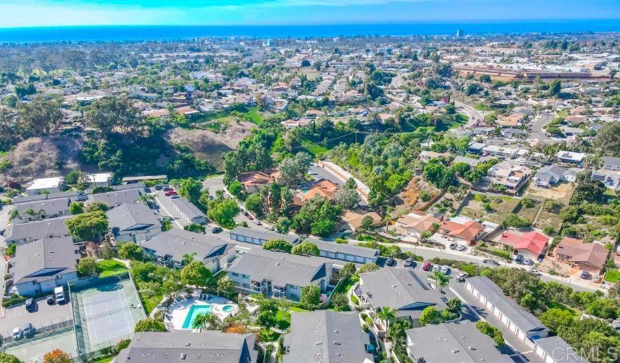 Ground Level Oceanside Condo in a Perfect Location! This gorgeous open concept home flooded with natural light and ocean breezes is a must see in the highly sought after Loma Alta neighborhood. Move in ready and great investment opportunity! Nestled within 1.5 miles to the beach, this bright and spacious condo is just moments to the Pier, parks, and the Harbor. With views of palm trees and greenery, this unit features gorgeous wood flooring, crown molding, pendant lighting, in-unit washer/dryer, and owned solar! As you enter the flowing floor plan, you cannot miss the updates and ocean breezes that flow throughout this charming home. Step out of your French doors and onto your spacious private front yard with patio area and turf lawn - perfect for enjoying your morning cup of coffee or watching the sunset as you BBQ with friends and family. The complex offers a sparkling pool, hot tub, tennis/pickleball and basketball courts with park-like grounds creating your own resort-style oasis. You have your own large single car garage and assigned parking space, with ample street parking also available. There are no stairs in this beautiful unit that includes a granite kitchen with breakfast nook and bar seating area, double undermount sink, stainless steel appliances and French door refrigerator. The primary retreat features a picturesque window, granite vanity, and walk-in closet with built ins. Additional highlights include A/C, remote ceiling fans, custom window coverings, new interior paint, instant water heaters, new lighting, and water and trash included with HOA. You will love this turn-key ready home in a perfect location! Situated in the coastal hills, you're just minutes to freeways, great restaurants, shopping, and parks. Great for commuters by bike, bus, or the Coastal Trains. Enjoy this coastal lifestyle with natural beauty, all while being moments away from the vibrant downtown and beaches.