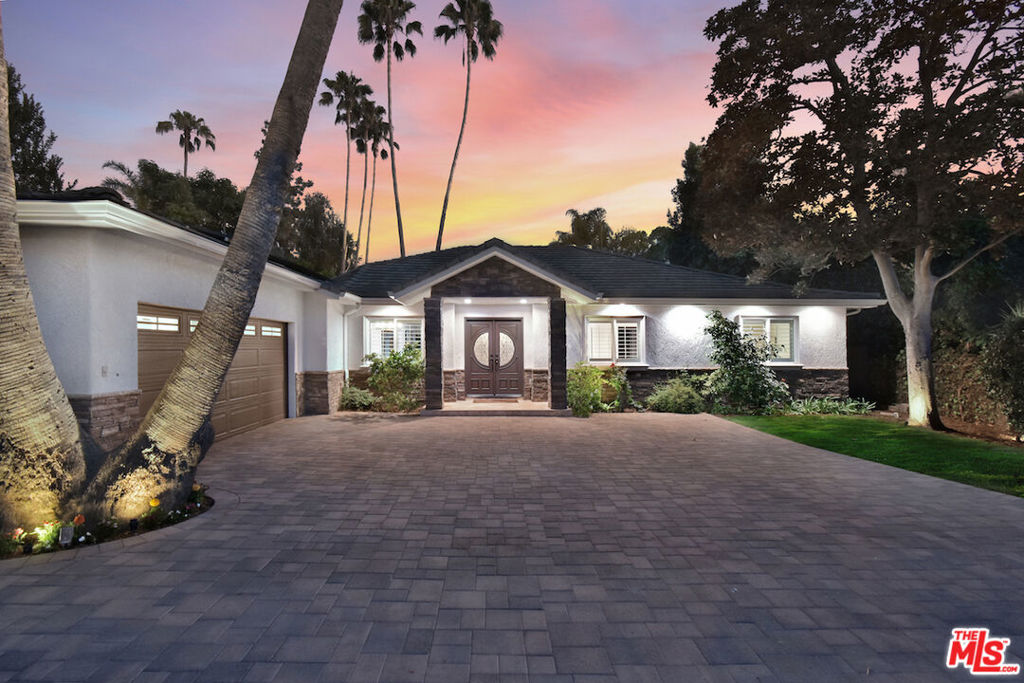 Located in Woodland Hills' prestigious Vista de Oro neighborhood, this luxurious, four bedroom contemporary home situated on a spacious 17,600 square foot lot, is an absolute entertainer's delight. A lovely circular drive, replete with new pavers, is surrounded by mature palms and exquisite landscaping, all of which lead to an impressive double door entry to a magnificent home. A spacious formal entry leads to a grand great room that features a high ceiling, recessed lighting, a stacked-stone fireplace and brand new flooring. French doors make up the entire back wall; they not only flood the room with natural light but seamlessly connect the indoors with the outdoors. The kitchen and dining area offer an open floor plan. The kitchen features black granite counters, a large center island, luxurious and plentiful cabinetry with new hardware, stainless steel appliances and a walk-in pantry. The kitchen also provides easy access to a conveniently located laundry room with built-in cabinetry, the two-car garage and the side patio. Directly adjacent to the kitchen is a conveniently located office/guest suite with recessed lights, a wall-length closet, lovely three-quarter bath and a private exit to the patio. The bedroom wing of this home features two large, light-filled bedrooms, each with an ample, well-lit custom built closet. The shared, well-appointed and recently renovated full hall bath is both luxurious and calming. One of the many highlights of this amazing home is the high end master suite. With its double door entry, it boasts a high, pitched ceiling, beautiful chandeliers, a stacked-stone fireplace and French doors that open to the patio. The suite also offers a very large walk-in closet and spa-like bath with two sinks and a separate glass-enclosed shower and large soaking tub. A private staircase leads to a huge gym or office with its own three-quarter bath. The grounds of this one in a million home are an entertainer's dream and offer the ultimate in luxurious privacy. The large covered patio with recessed lighting, perfect for al fresco dining, is surrounded by multiple grassy areas with mature palms and manicured flowering bushes. The sparkling swimming pool also features a fantastic pool bath. The outdoor entertainment area, which spans in excess of eight hundred square feet, features a concrete bar and BBQ center as well as a fully-roofed pavilion with seating for even the largest of get-togethers. With its concrete tile roof, solar panels for energy efficiency and brand new heating and air conditioning, this is truly an incredible home with so much to offer. While in a country-like setting, it is conveniently located to fine dining and shopping on Ventura Boulevard, Westfield Topanga mall, The Village and Whole Foods as well as to Target and Costco. You will be minutes from both the beach and hiking/cycling in the Santa Monica Mountains. Come see this amazing property, located at 20544 DeForest Street in Woodland Hills. You'll want to move in tomorrow!