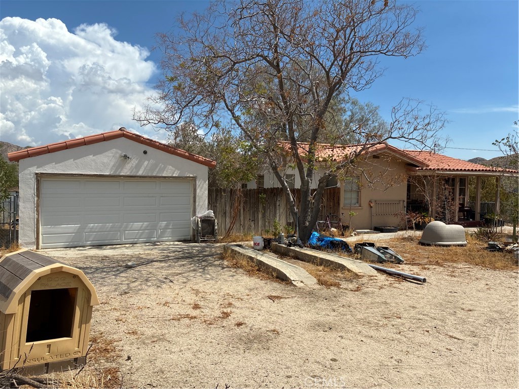 Cute single story with a lot of potential. Nice front porch. Large Mountain view lot. Easy access/short distance off of 29 Palms Hwy/ CA 62. Fully Fenced. Tile Roof. Vaulted ceilings in the living room. Service porch with laundry hookups. 2 car garage. Shed and workshop area. Chicken pens. Newer house on one side, and well-kept water company on the other side. House has a lot of personal property/junk that needs to be removed/recycled. Sold AS IS. Cash.