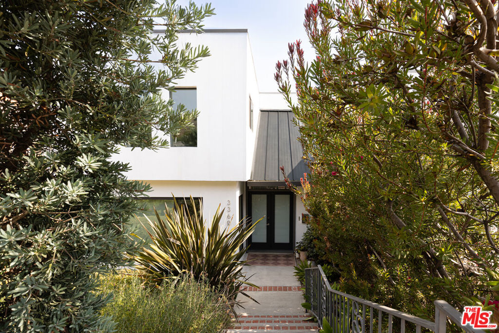 Peaceful, private, and hedged 1960s Los Feliz 3-story Contemporary masterpiece evoking Palm Springs vibes. This recently renovated magnificent showstopper boasts 4 bedrooms, 4 baths, stunning views, incredible bonus space, and even more possibility for expansion and upside. Drama and wonder can be found here at every turn. To begin, the stately double-door entryway features original Terrazzo floors, a dramatic sweeping staircase, and soaring pitched ceilings. A generous step-down living room sets the tone for easy, sophisticated living. Prime for entertaining, an elegant formal dining room flows seamlessly through sliding doors out to an absolutely awe-inspiring deck which is anchored by a breathtaking view of the surrounding hills and mountains and also includes a built-in hot tub, sauna, and multiple congregating areas to relax, lounge, and play. A bright chef's eat-in kitchen, spacious family room, and guest powder room complete the primary level. The second level features a luxurious primary suite boasting sunny, harmonious views, walk-in closet, and en suite bathroom with dual sinks and custom tile. Three additional generously-sized bedrooms and two more full bathrooms complete the upper level. The lower level features a dedicated laundry room, plenty of storage, and an additional expansive bonus room downstairs (approx 400 sf) which could be transformed into whatever your heart desires - a perfect second family room, screening room, game room/playroom, gym, or guest quarters. Two-car garage with direct access to the home. A stone's throw to Los Feliz Village and a plethora of local favorites including Alcove Bakery & Cafe, All Time, Encanto, Jeni's, Little Dom's, Lou's Wines, Maru, and MessHall. Griffith Park trails, the Observatory, easy freeway access, and concerts at The Greek are always at your fingertips. Lushly landscaped and completely private, this dynamite home is truly the ultimate sanctuary.