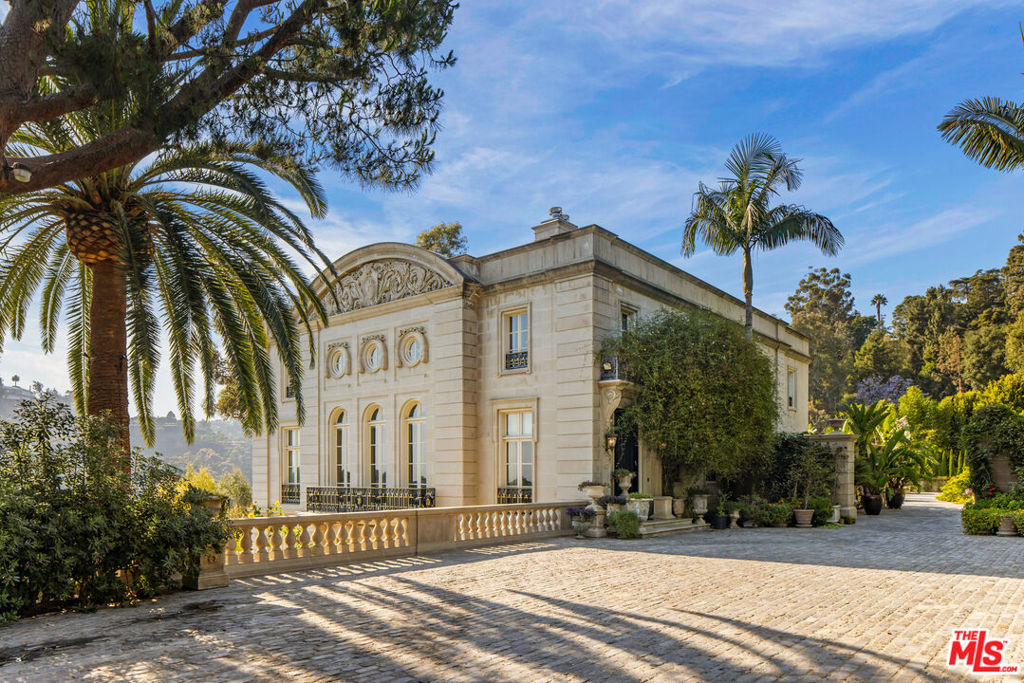 A Chateau in Bel Air where French refinement and architectural design meet Los Angeles city and ocean vistas. This magnificent estate was modeled after Le Petit Trianon in Versailles, France. The grand interior with double-height ceilings decorated with meticulously crafted moldings offers elegantly appointed formal living rooms. Just one floor below, informal quarters provide spaces to casually luxuriate after laps in the pristine pool under the California sun. And movie nights are sure to delight in the sumptuously comfortable home theater conveniently adjacent to the wine room. For those who love to entertain in grand style, this estate offers an approximately 10,000sf open air terrace complete with an outdoor kitchen, cabana room and city views. Offering 9 bedrooms and 12 bathrooms, including the guest house and maid's quarters, this home presents a truly unique opportunity. One of the most distinctive features of this estate is the 22-car garage situated directly below the open-air terrace. Live elegantly and entertain in style with the Los Angeles skyline in the background while hosting all your favorite people under one roof. Grand in every detail (including the parking)!
