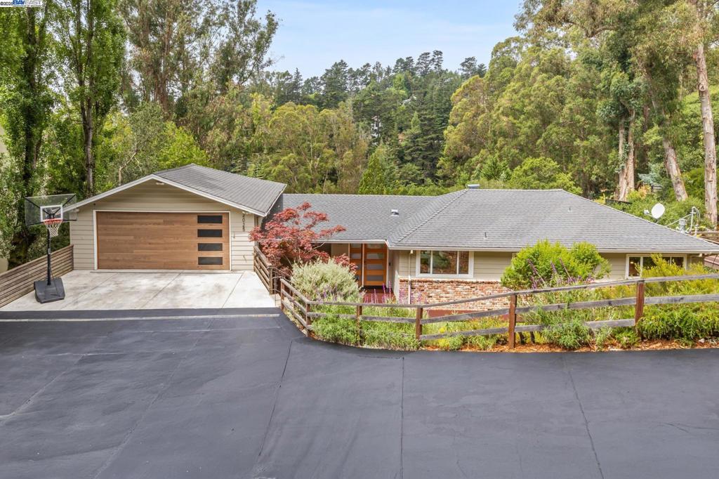 Nestled in a private, wide lot in a beautiful oak grove canyon in Montclair rests this upgraded 4BD/3BA Mid-century home offering spacious, flexible indoor/outdoor living. The 2599 SQFT home welcomes you down a long driveway and into its front garden with a deck, covered porch with recessed lights, raised beds, and level turf area to play. Step inside the spacious living and dining area to see gorgeous wooded views from a giant picture window and sliding glass doors opening to an expansive and private deck. Perched above the trees, entertain friends, sip your morning coffee, or spend time with family. The stylishly remodeled kitchen features top-of-the-line appliances and peninsula for seating. Down a sleeping wing for peace and quiet, find a hall bath and three bedrooms, including the primary with an ensuite bath. On the lower level (an opportunity for a separate apartment) there’s a huge fourth bedroom, a large split bath with tub and shower, a laundry room with fridge/freezer, and a giant flexible room with wet bar, and sliding glass doors onto another deck. This area offers many possibilities for work, living, or play. The home enjoys storage galore and over-sized 2-car garage. Just down the road, enjoy the East Bay parks, Montclair Village and sought-after public schools.