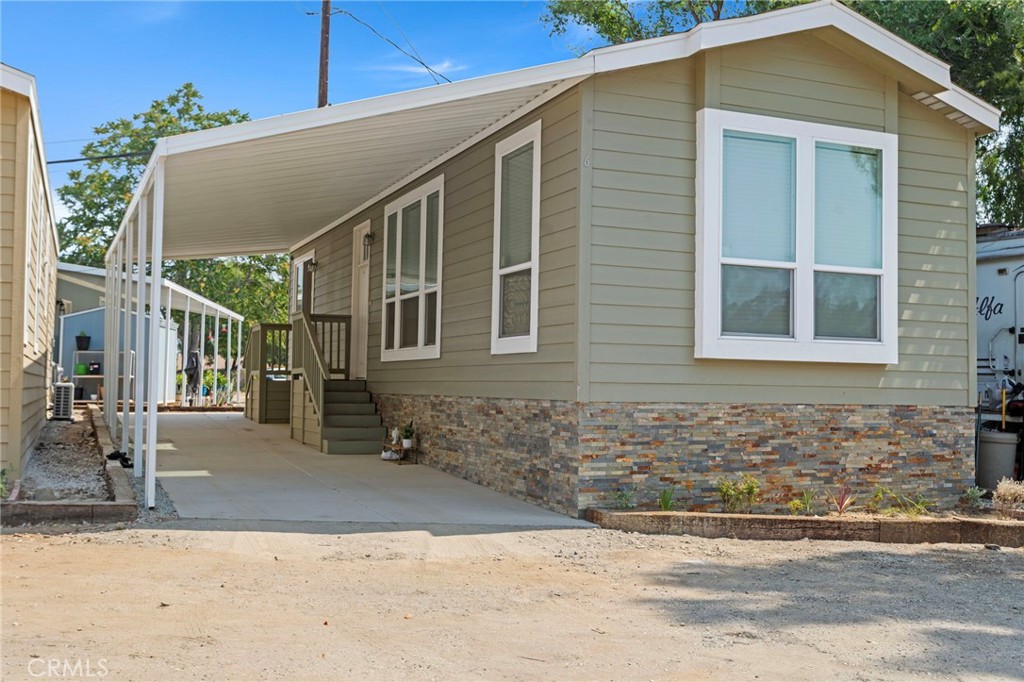 Sycamore Park is an all-age mobile home community located in Grand Terrace, California and has 21 homes, built on over 3+ acres, green open spaces, with many mature trees. The community sits at the top of a hill with unobstructed views to the West that are pleasing during the day and amazing at night. Ownership recently finished the improvements to the entrance of the Park that will signal to your family and friends that this is not a typical mobile home community. The community is accessed through electric gates and has a separate pedestrian gate that requires a code to enter. As you enter the community you are greeted by a mini park that offers walking paths, dessert gardens, and benches to enjoy the scenery and just take in the tranquility of the Park. There is a community laundry room and a storage area. The home is a brand new 2023 Skyline model, custom built with 2 bedrooms and 1 bath. The exterior will receive a full cement driveway covered with a custom awning, and corresponding skirting. The kitchen comes with stainless steel appliances such as the stove with an over the range microwave, refrigerator, garbage disposal and a separate step-in pantry. The dining room and living room are an open concept adjacent to the kitchen. The bathroom has a bathtub with an integrated shower and a built-in linen cabinet. There is a laundry room within the home with hookups for a washing machine and gas/electric dryer and overhead storage. The custom-built homes boast high-quality features such as, 9 ft ceilings throughout, oversized panoramic bay windows in the front, many tall wide windows throughout drawing in natural light, high grade laminate flooring, Shaker style cabinets by Skyline Gallery with matching counter tops and vanities in the bathroom. The home comes central air ready with central heat installed and are serviced by a 100amp. We have 5 homes to choose from with different kitchen and exterior colors. Call for an appointment to tour the Park and choose your home site today.